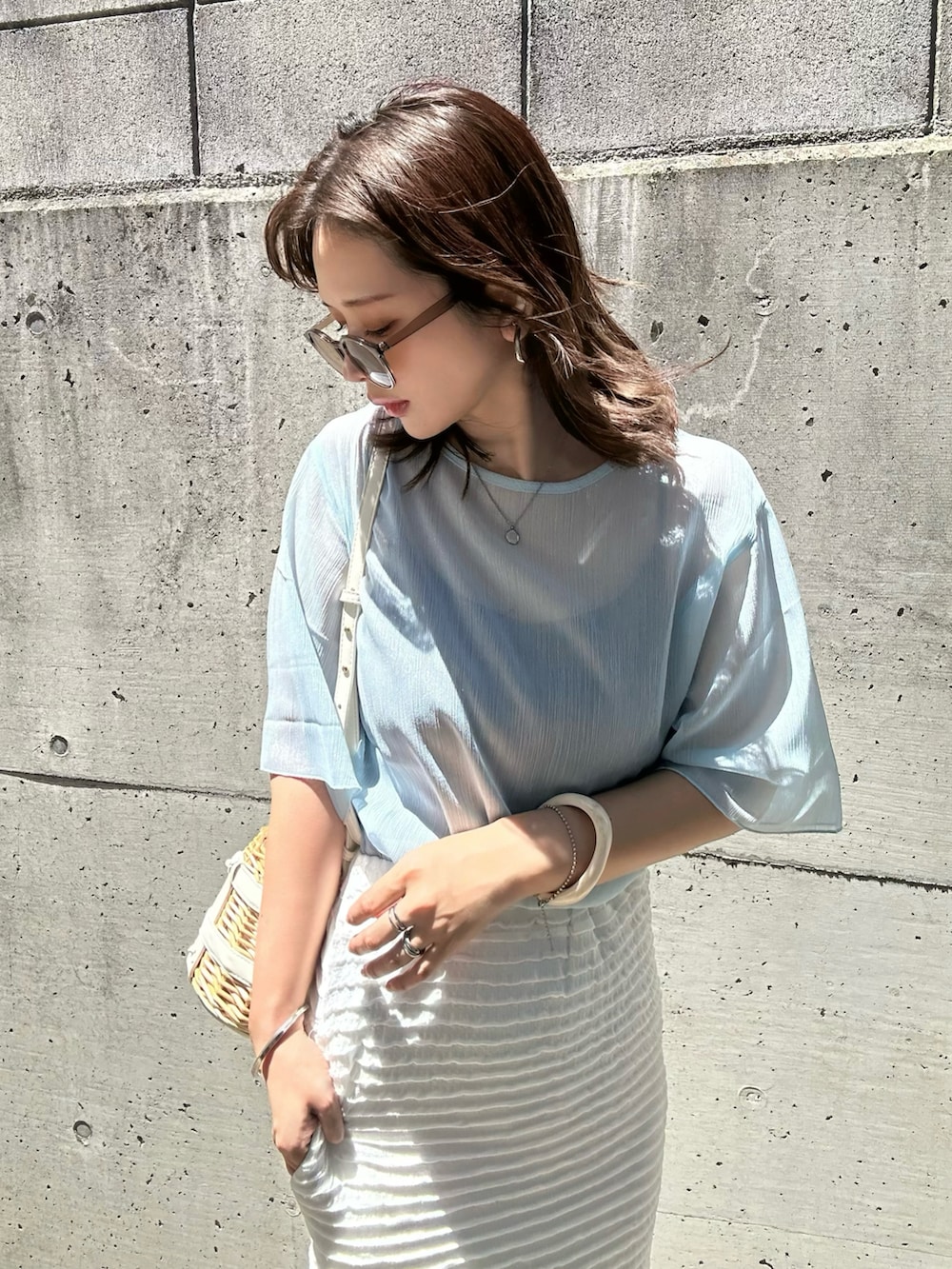 ブルー系のシャツ/ブラウス、ホワイト系のスカート、ホワイト系のかごバッグを着用したレディースの夏コーディネートの3枚目の写真