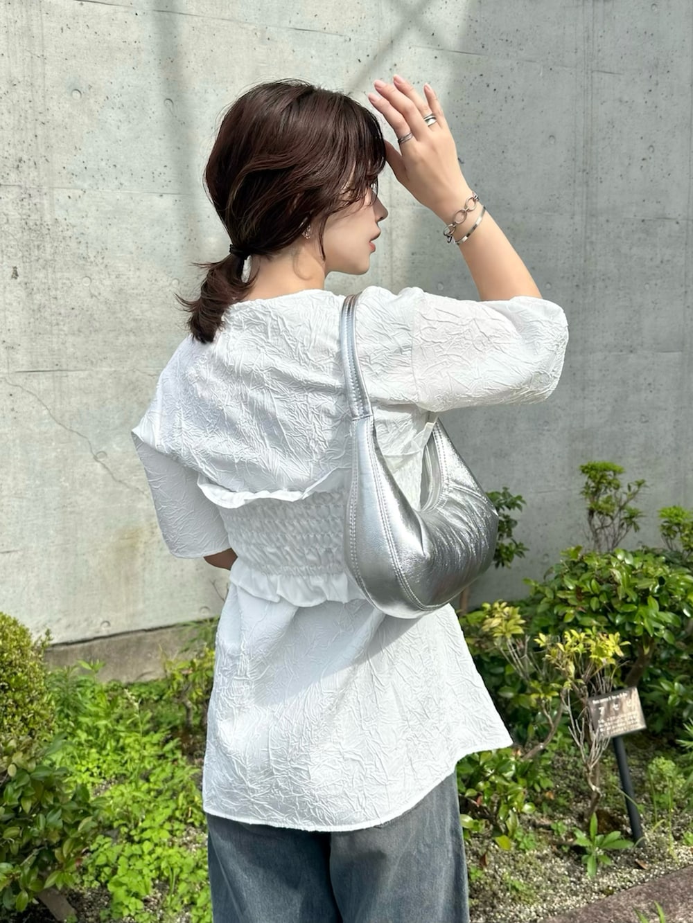 ホワイト系のTシャツ/カットソー、ブルー系のデニムパンツ、シルバー系のバッグを着用したレディースの夏コーディネートの5枚目の写真