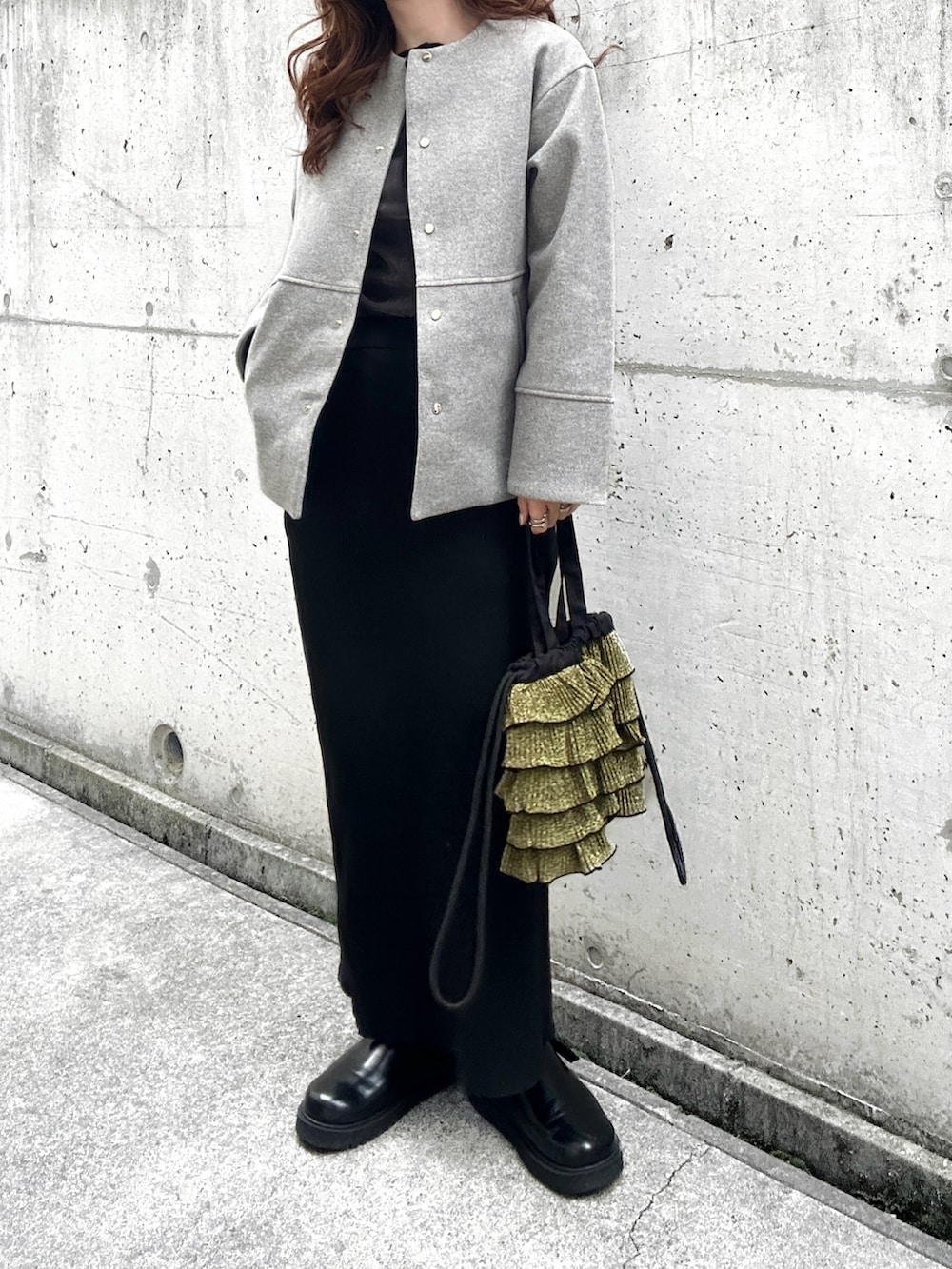 グレー系のTシャツ/カットソー、グレー系のノーカラーコート、ブラック系のスカートを着用したレディースの秋コーディネートの2枚目の写真