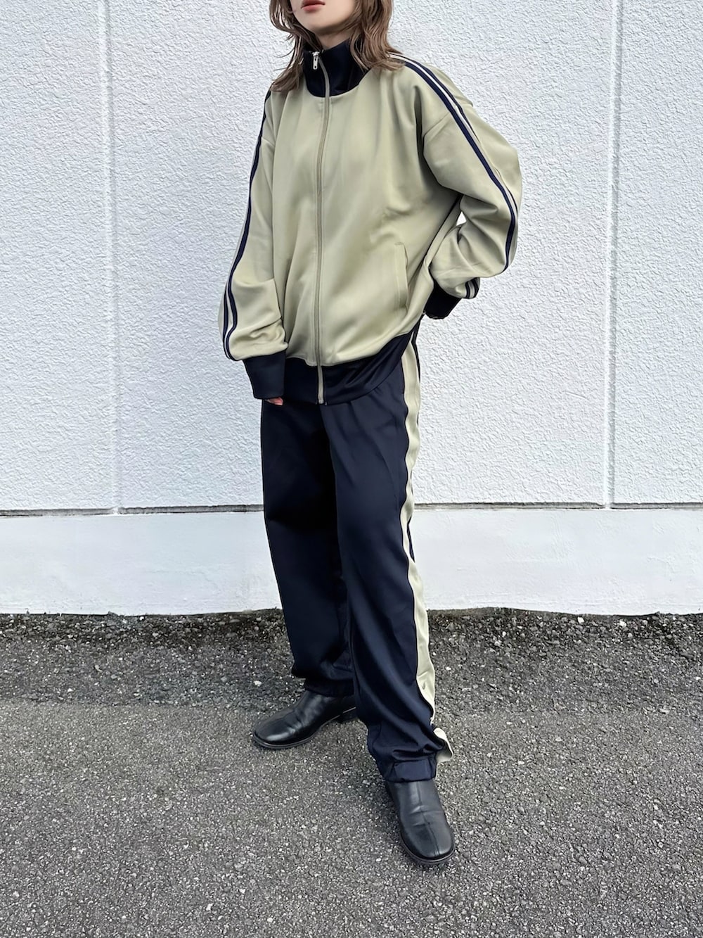 ベージュ系のジャージ、ブルー系のスウェットパンツ、ブラック系のその他シューズを着用したレディースの秋コーディネートの3枚目の写真