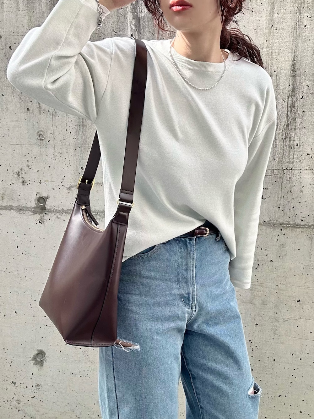 ホワイト系のニット/セーター、グレー系のニット/セーター、ブルー系のデニムパンツを着用したレディースの冬コーディネートの5枚目の写真