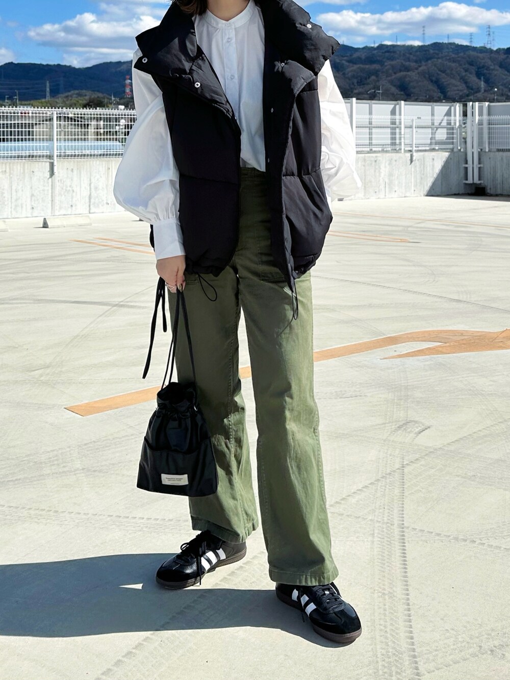 ホワイト系のシャツ/ブラウス、グリーン系のパンツ、ブラック系のショルダーバッグを着用したレディースの春コーディネートの3枚目の写真