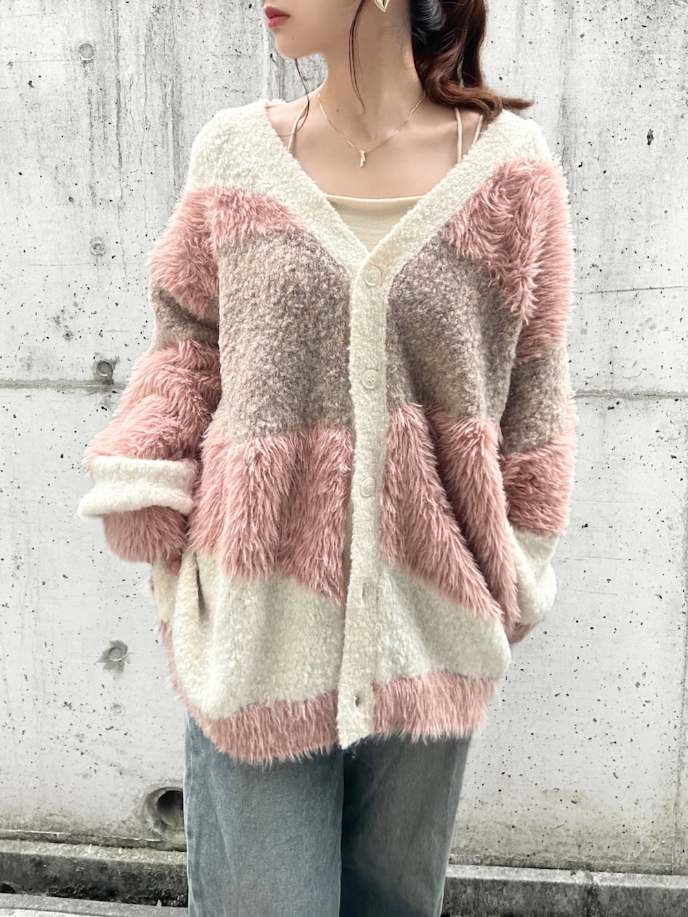 ホワイト系のカーディガン/ボレロ、ホワイト系のキャミソール、ブルー系のデニムパンツを着用したレディースの秋コーディネートの5枚目の写真