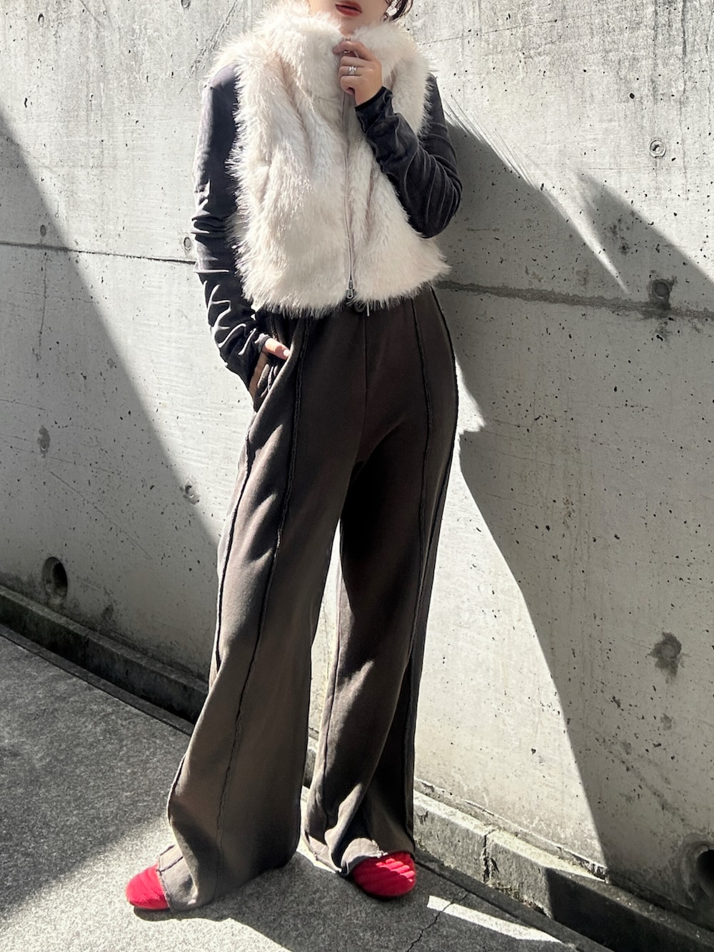 ホワイト系のベスト、グレー系のTシャツ/カットソー、ブラック系のスウェットパンツを着用したレディースの秋コーディネートの2枚目の写真