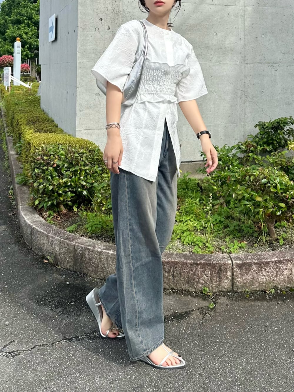 ホワイト系のTシャツ/カットソー、ブルー系のデニムパンツ、シルバー系のバッグを着用したレディースの夏コーディネートの2枚目の写真