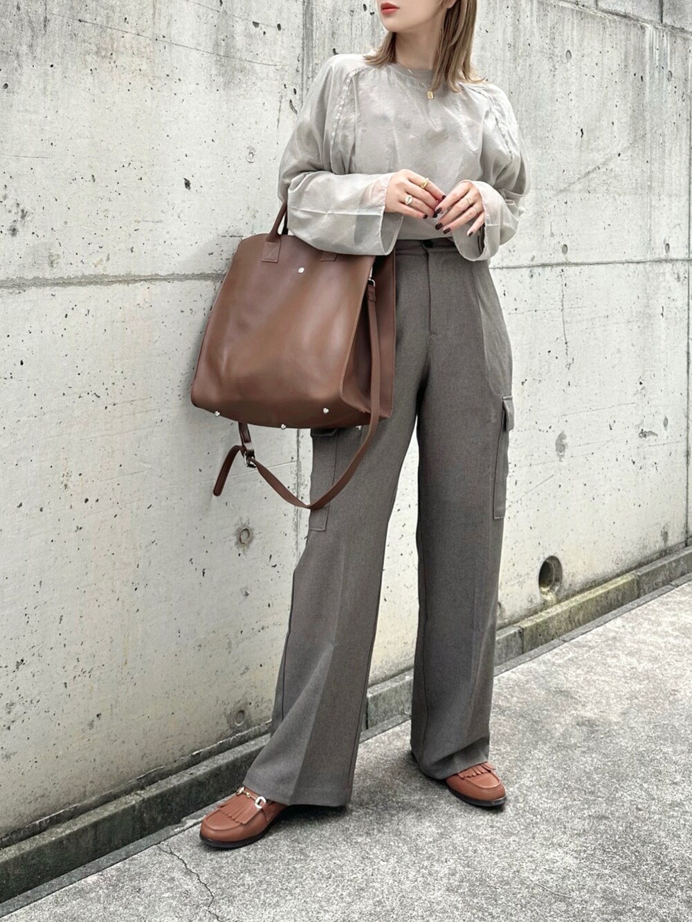 ベージュ系のシャツ/ブラウス、ブラウン系のカーゴパンツ、ブラウン系のバッグを着用したレディースの秋コーディネートの2枚目の写真