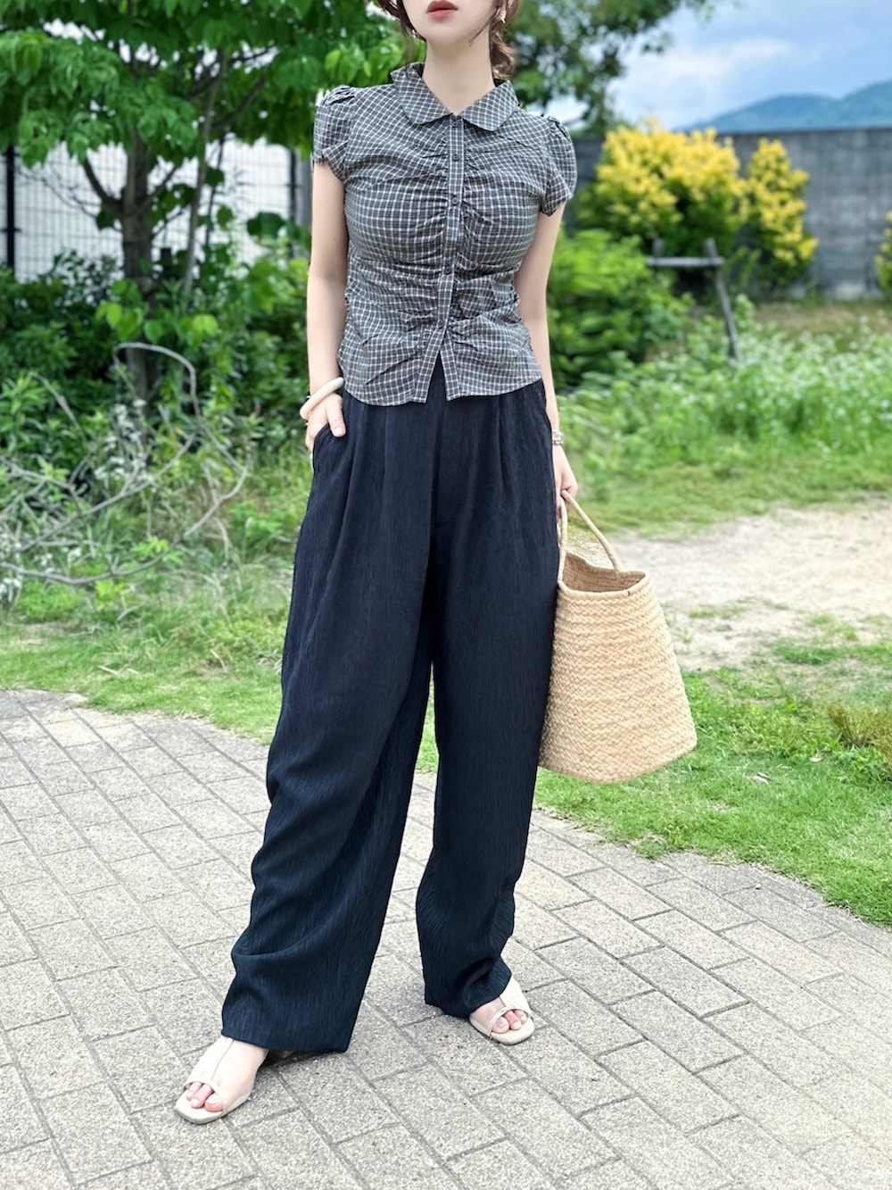 ブラック系のシャツ/ブラウス、ブルー系のデニムパンツ、ベージュ系のかごバッグを着用したレディースの夏コーディネートの2枚目の写真