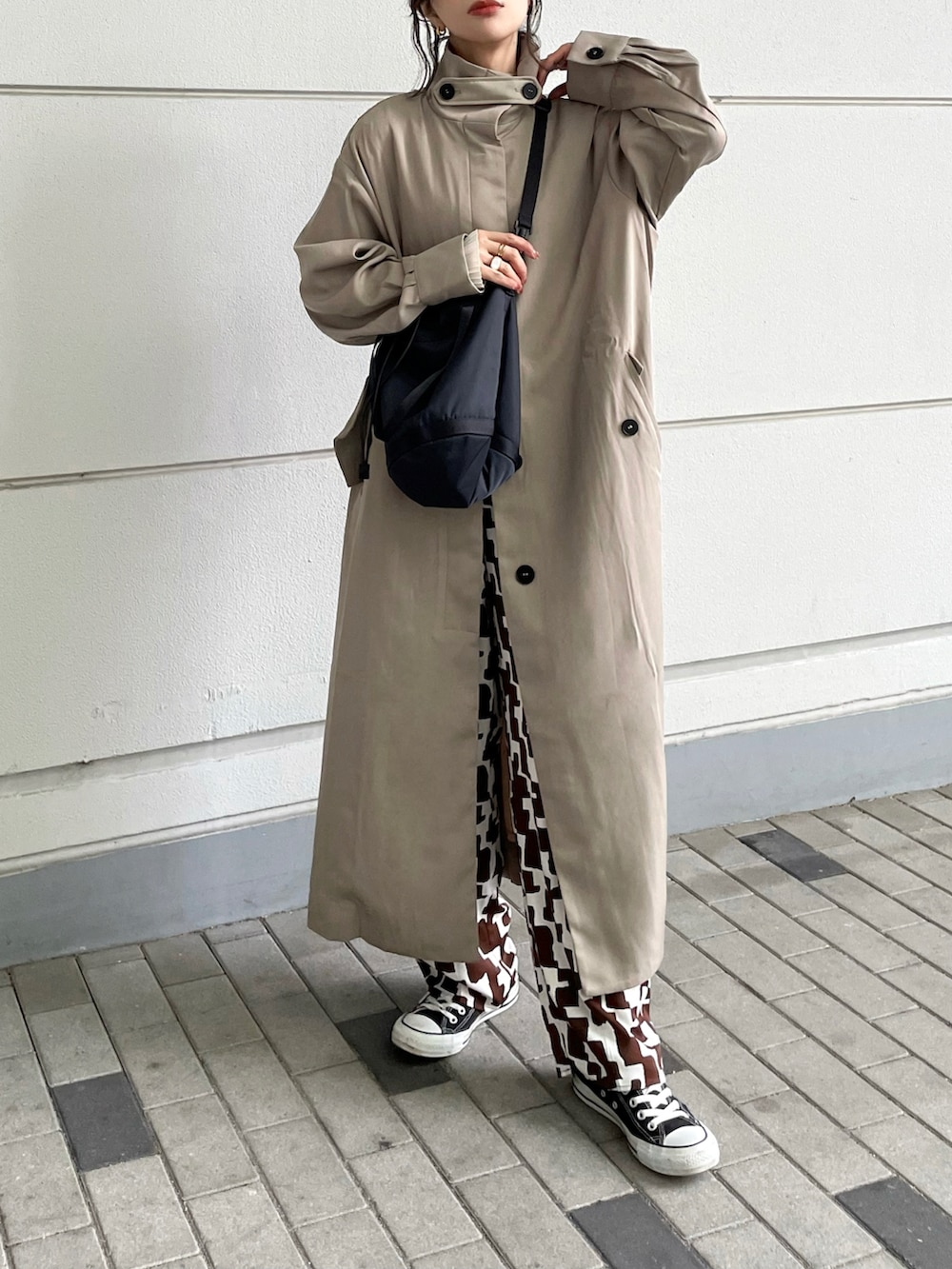 ベージュ系のトレンチコート、ブラウン系のパンツ、ブラック系のバッグを着用したレディースの冬コーディネートの5枚目の写真