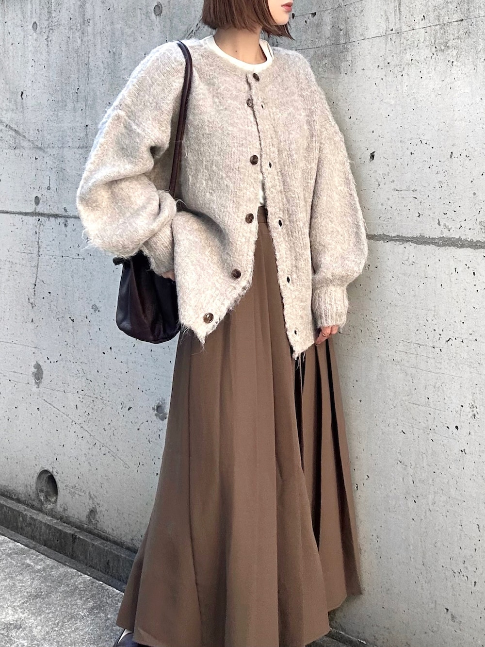 ベージュ系のカーディガン/ボレロ、ホワイト系のTシャツ/カットソー、ブラウン系のスカートを着用したレディースの秋コーディネートの4枚目の写真