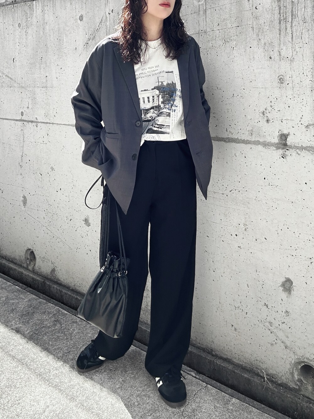 グレー系のテーラードジャケット、ホワイト系のTシャツ/カットソー、ブラック系のショルダーバッグを着用したレディースの春コーディネートの2枚目の写真