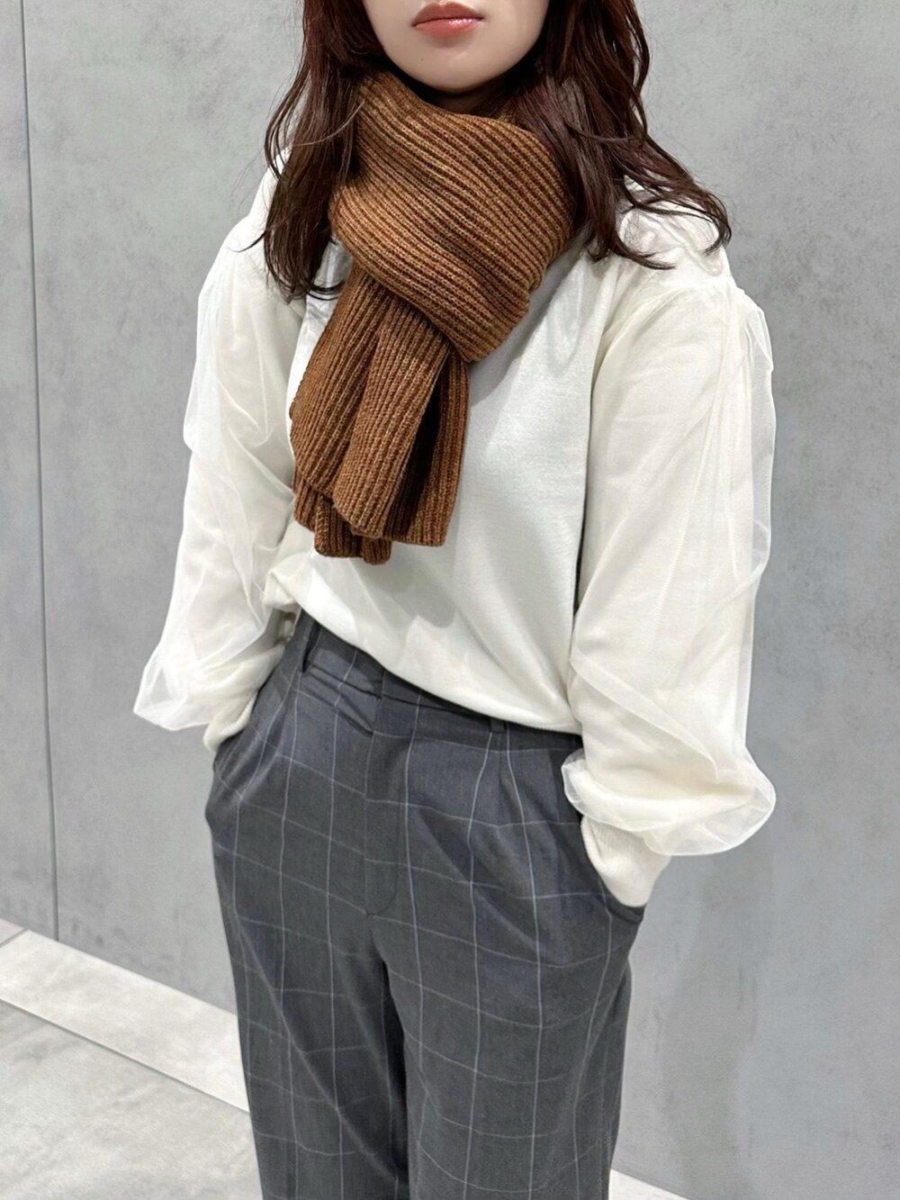 ホワイト系のニット/セーター、グレー系のパンツ、ブラウン系のショルダーバッグを着用したレディースの冬コーディネートの4枚目の写真