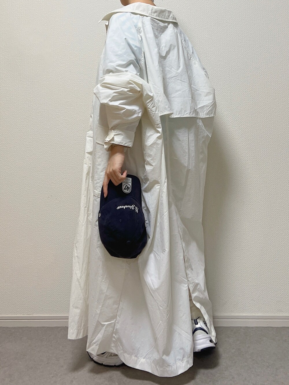 ブルー系のTシャツ/カットソー、ホワイト系のステンカラーコート、ホワイト系のスニーカーを着用したレディースの春コーディネートの3枚目の写真