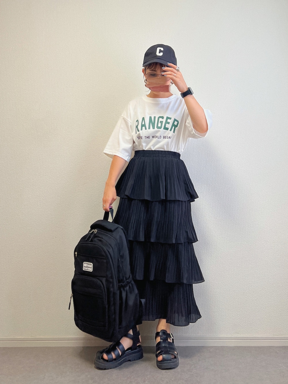 ブラック系のショルダーバッグ、ブラウン系のTシャツ/カットソー、ホワイト系のTシャツ/カットソーを着用したレディースの夏コーディネートの2枚目の写真