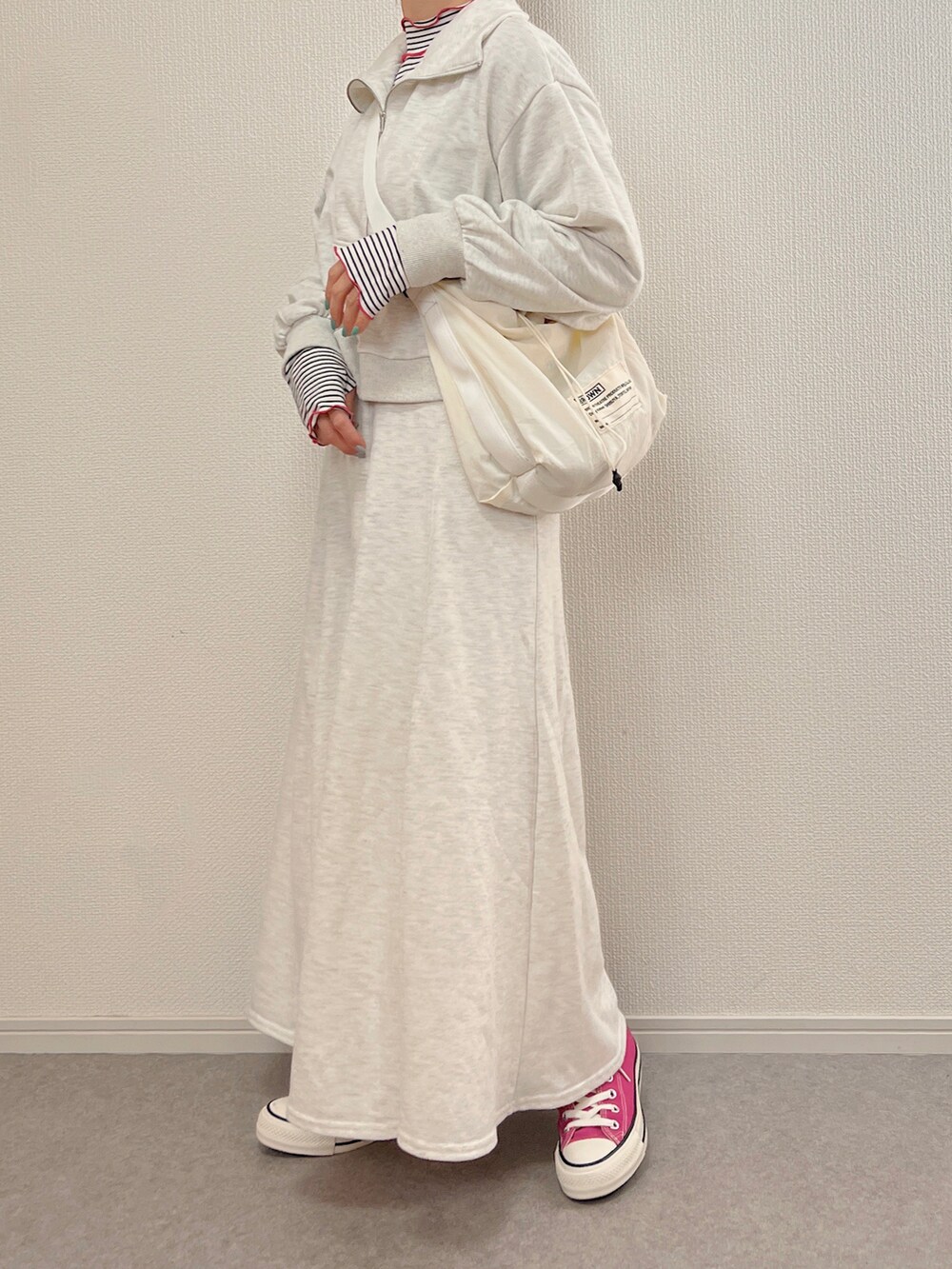 ホワイト系のショルダーバッグ、ピンク系のスニーカーを着用したレディースの冬コーディネートの2枚目の写真