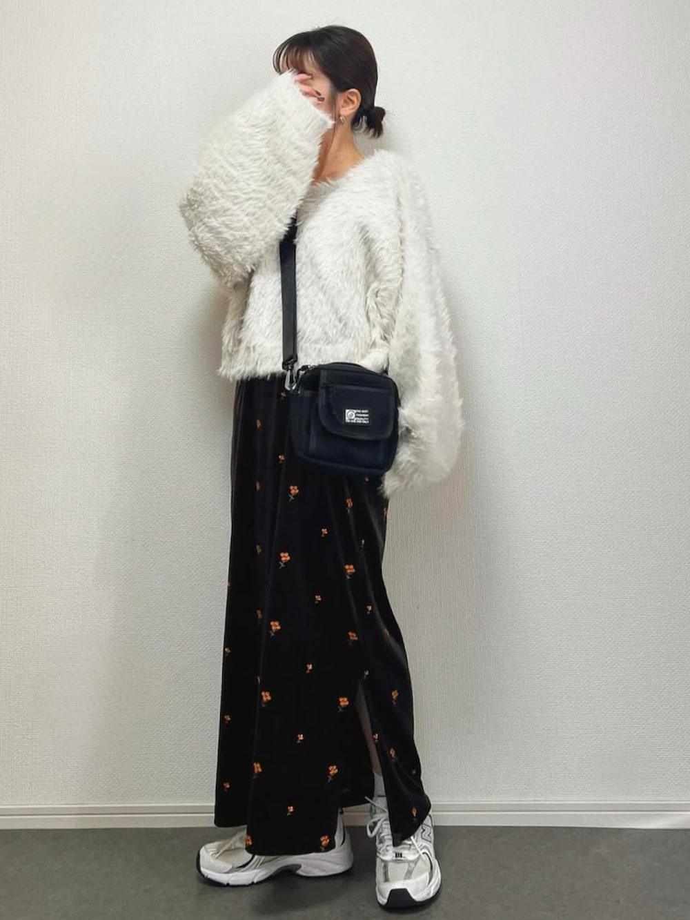 ホワイト系のニット/セーター、ブラウン系のワンピース、シルバー系のスニーカーを着用したレディースの冬コーディネートの2枚目の写真