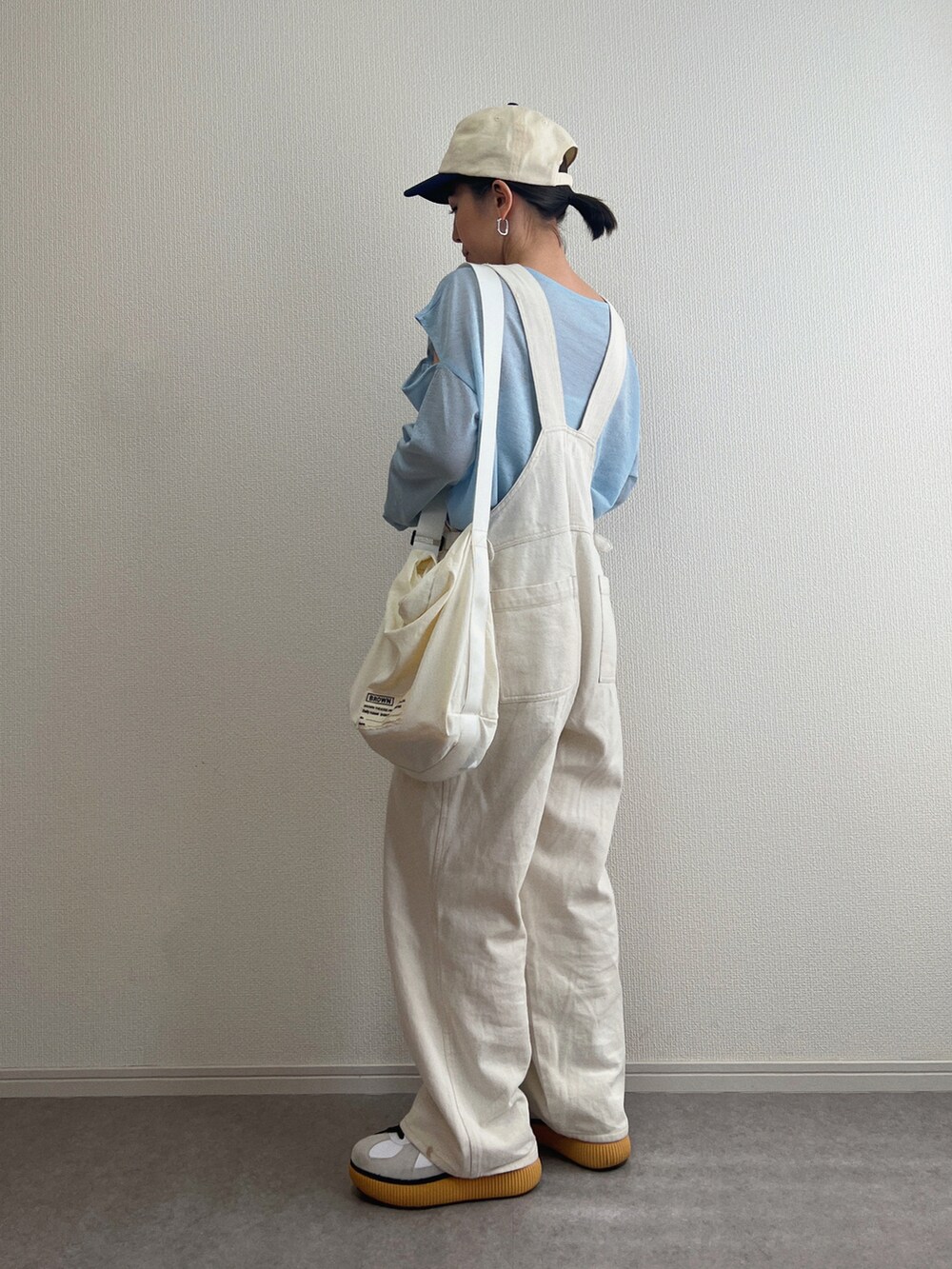 ブルー系のTシャツ/カットソー、ホワイト系のスニーカー、ブルー系のキャップを着用したレディースの春コーディネートの2枚目の写真