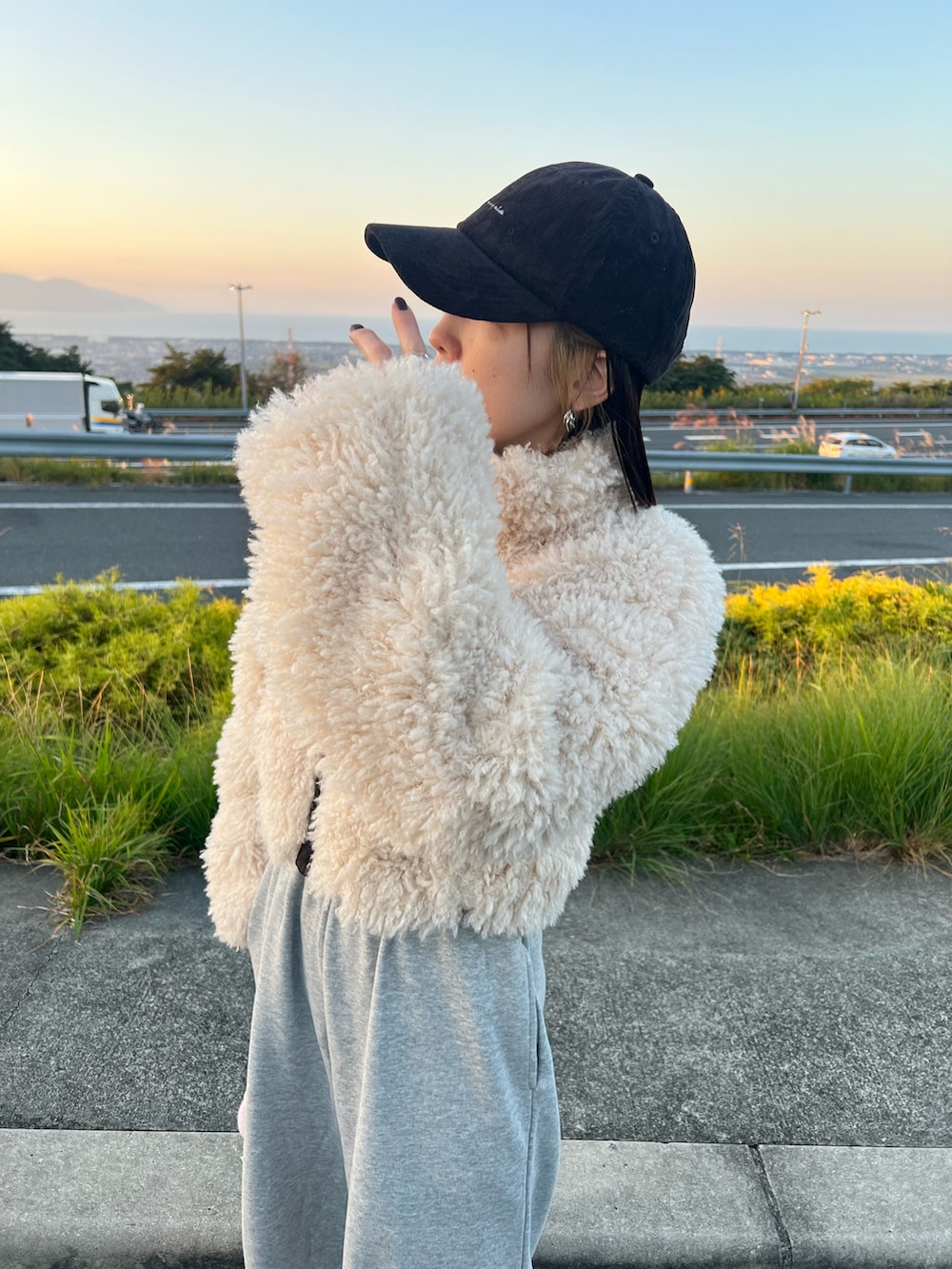 ホワイト系のブルゾン、グレー系のスウェットパンツ、ブルー系のスニーカーを着用したレディースの秋コーディネートの2枚目の写真