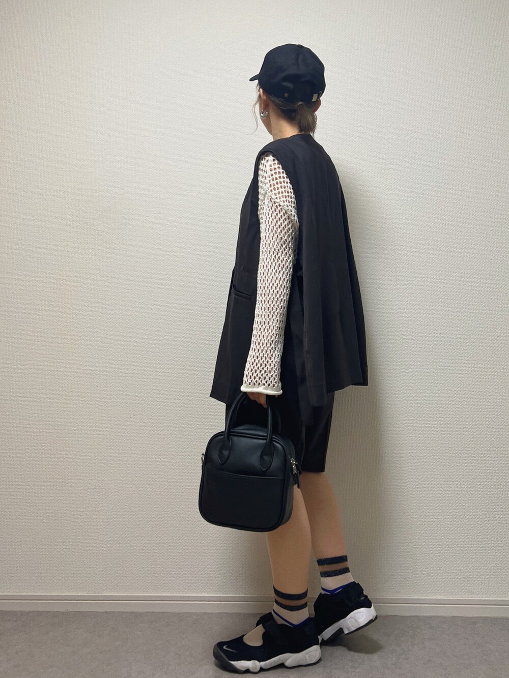 ブラック系のベスト、ブラック系のその他パンツ、ブラック系のサンダルを着用したレディースの春コーディネートの2枚目の写真