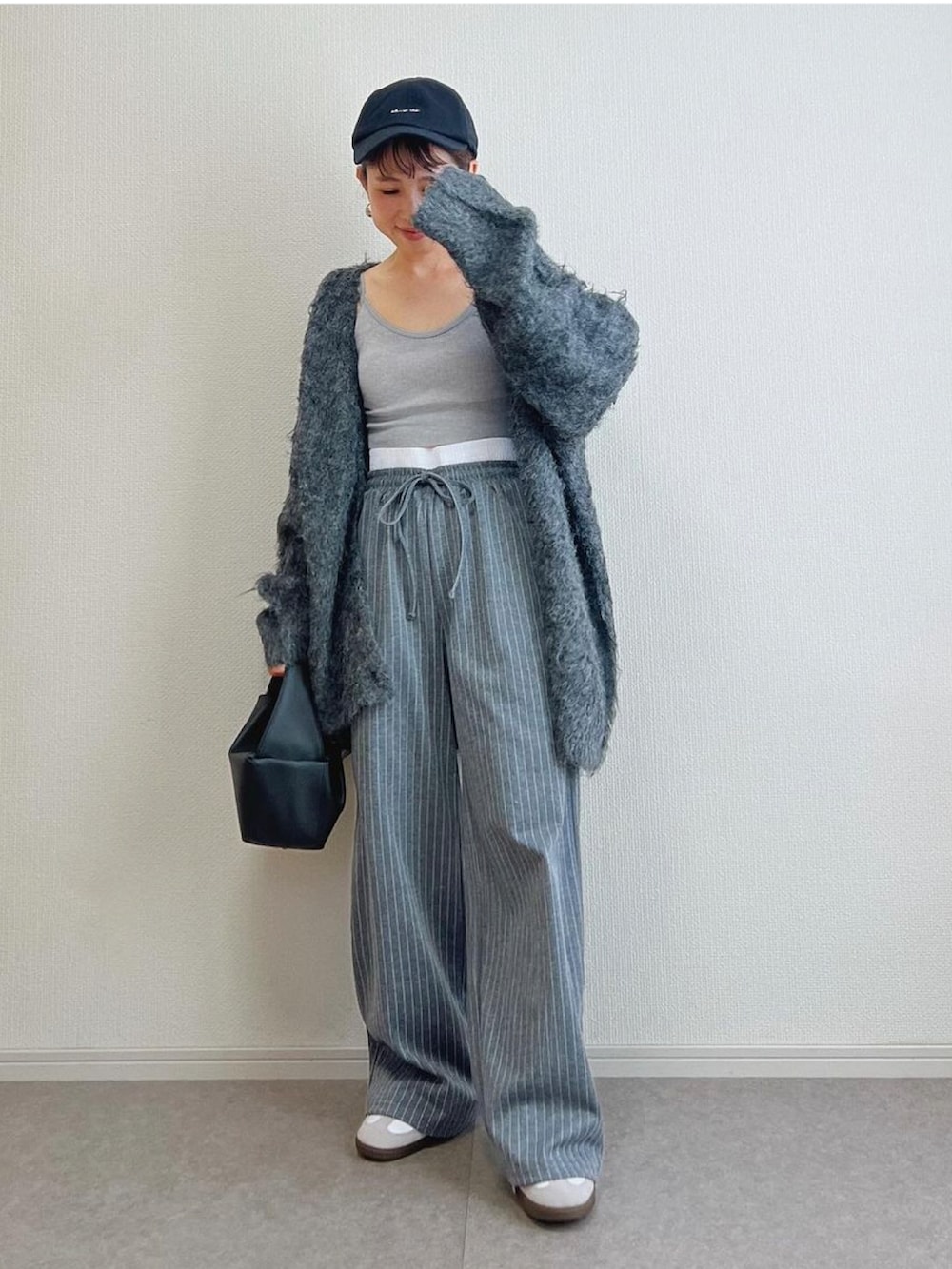 グレー系のカーディガン/ボレロ、グレー系のその他パンツ、ホワイト系のスニーカーを着用したレディースの秋コーディネートの2枚目の写真