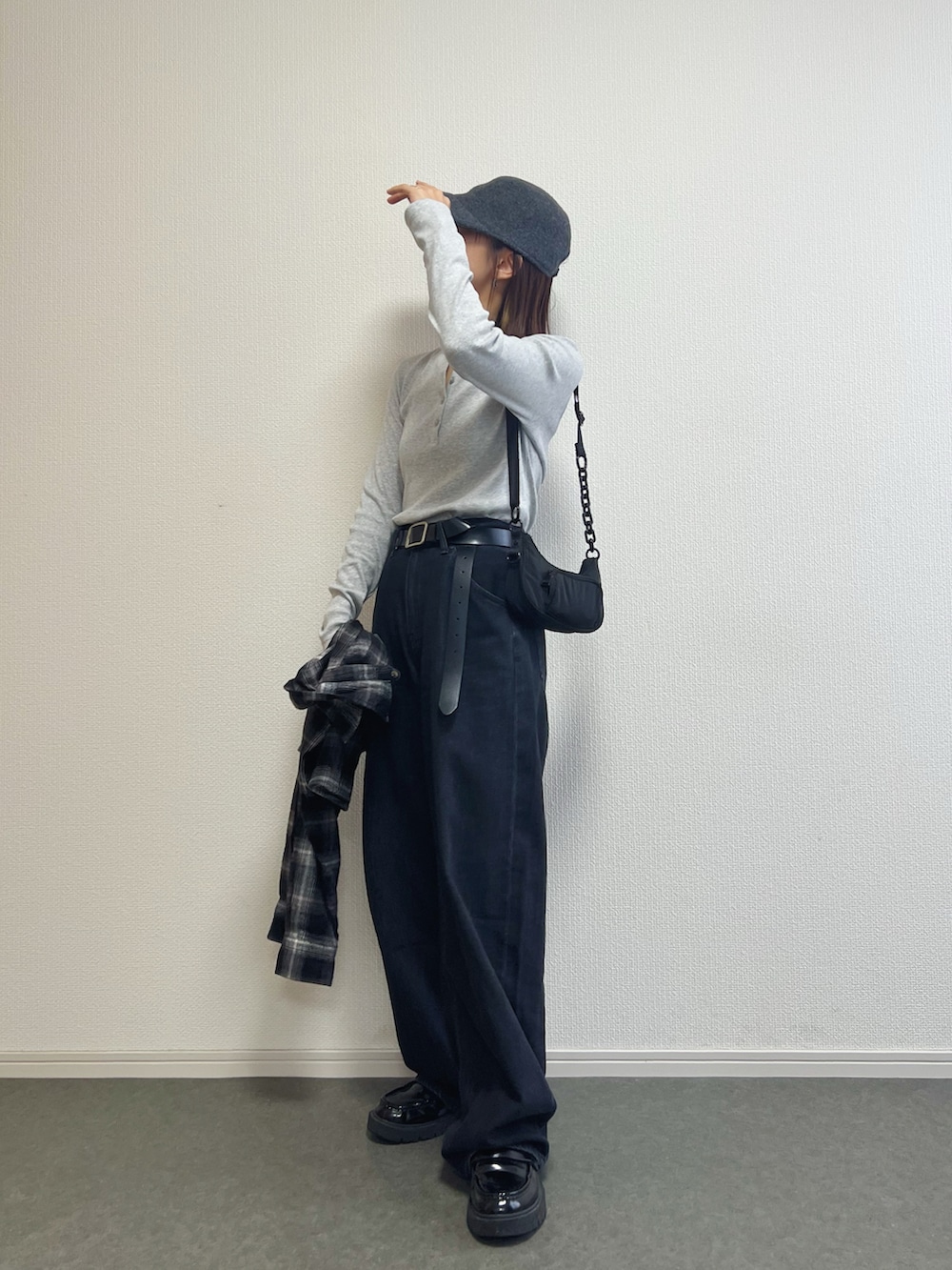 グレー系のトップス、ブラック系のデニムパンツを着用したレディースの秋コーディネートの2枚目の写真