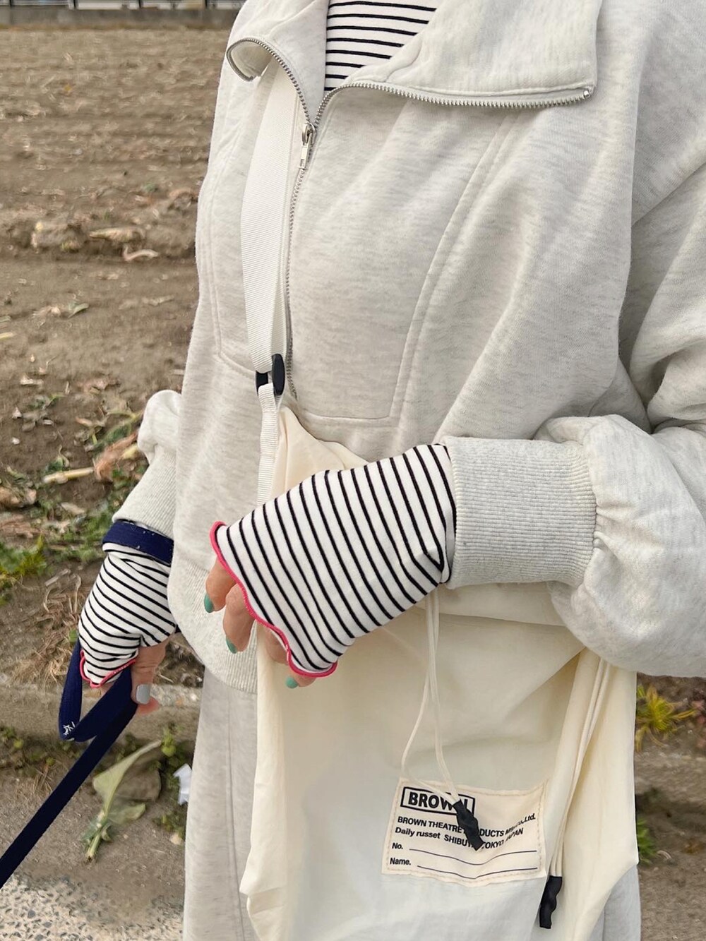 ホワイト系のショルダーバッグ、ピンク系のスニーカーを着用したレディースの冬コーディネートの3枚目の写真