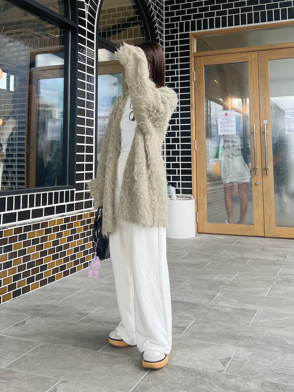 ブラック系のボストンバッグ、グレー系のカーディガン/ボレロ、ホワイト系のスニーカーを着用したレディースの秋コーディネートの2枚目の写真