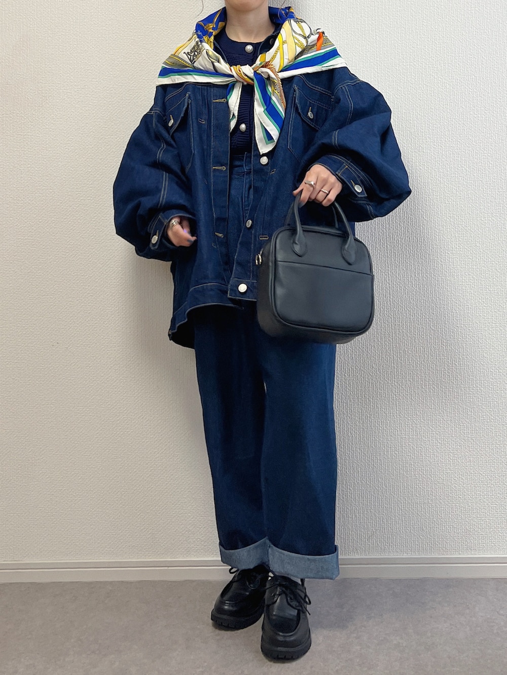 ブルー系のデニムジャケット、ブルー系のデニムパンツ、ブラック系のローファーを着用したレディースの春コーディネートの2枚目の写真