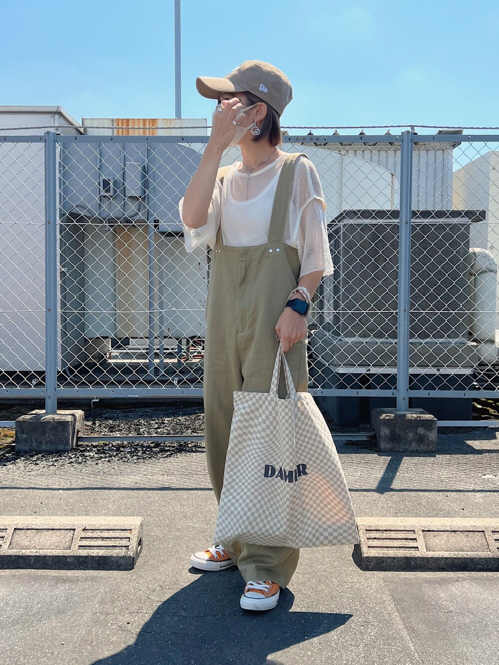 ベージュ系のトートバッグ、ベージュ系のサロペット/オーバーオール、オレンジ系のスニーカーを着用したレディースの夏コーディネートの3枚目の写真