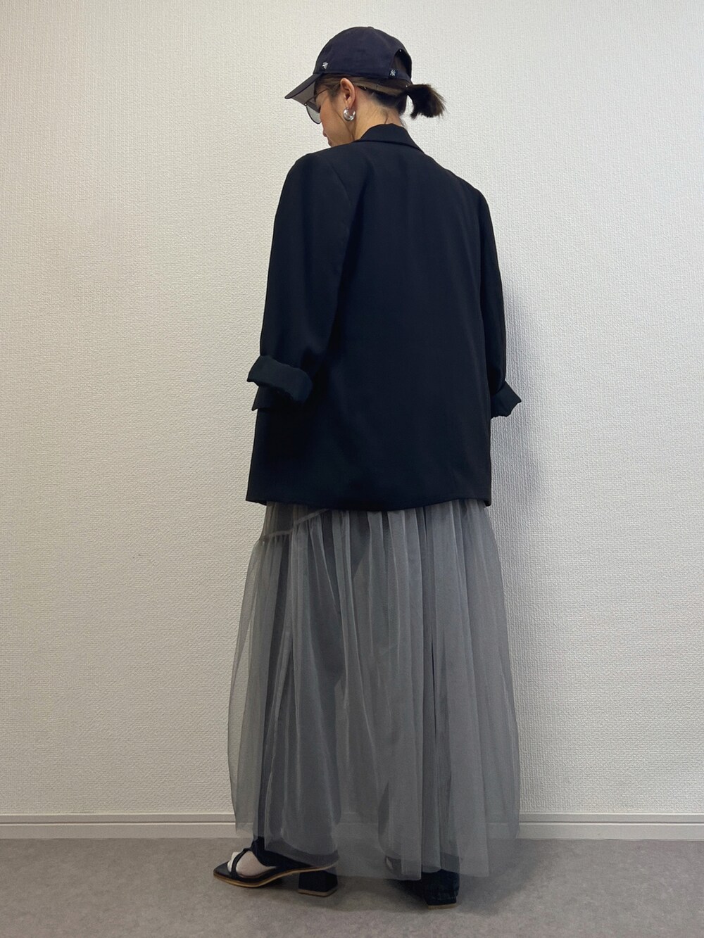 ブラック系のデニムパンツ、ブラック系のサンダルを着用したレディースの春コーディネートの3枚目の写真