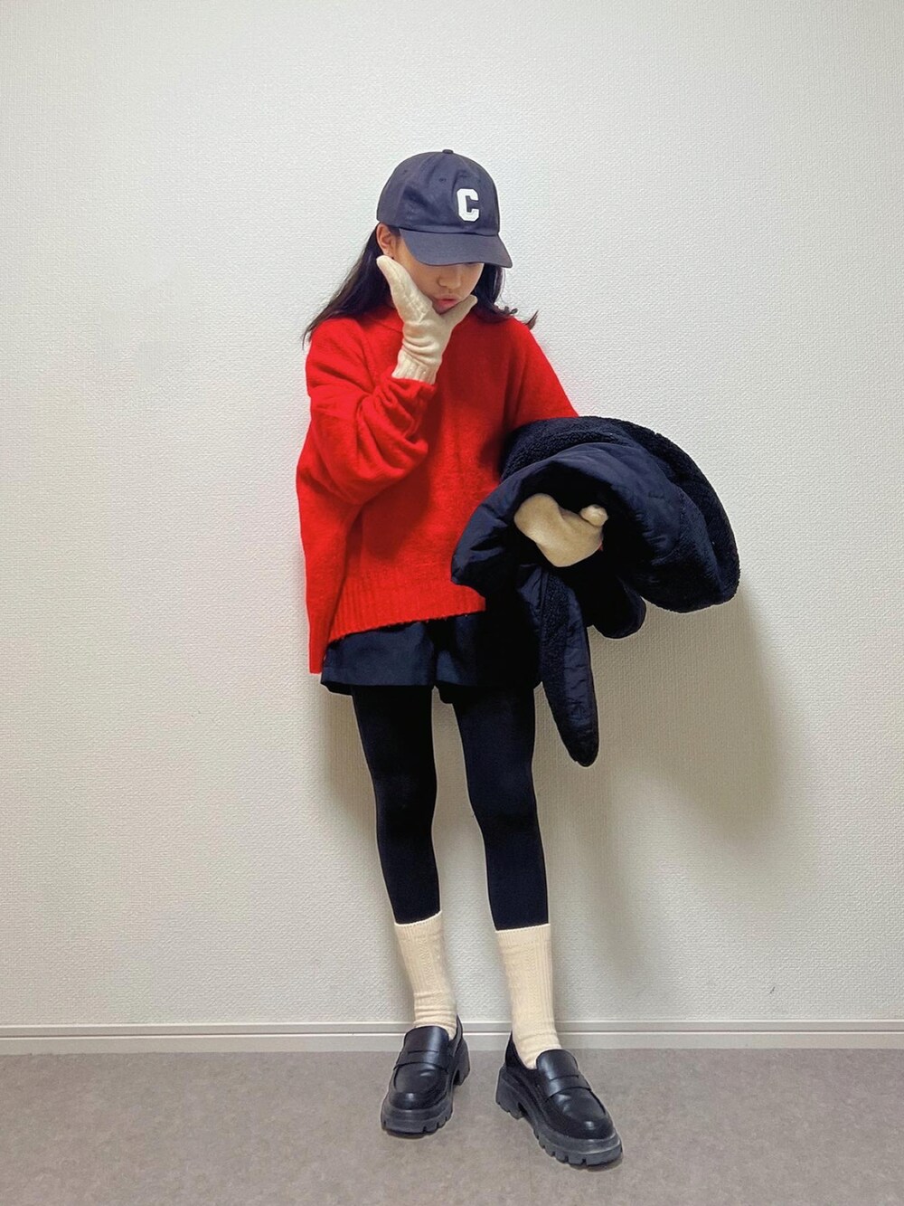 レッド系のニット/セーター、ブラック系のキャップを着用したキッズの冬コーディネートの2枚目の写真