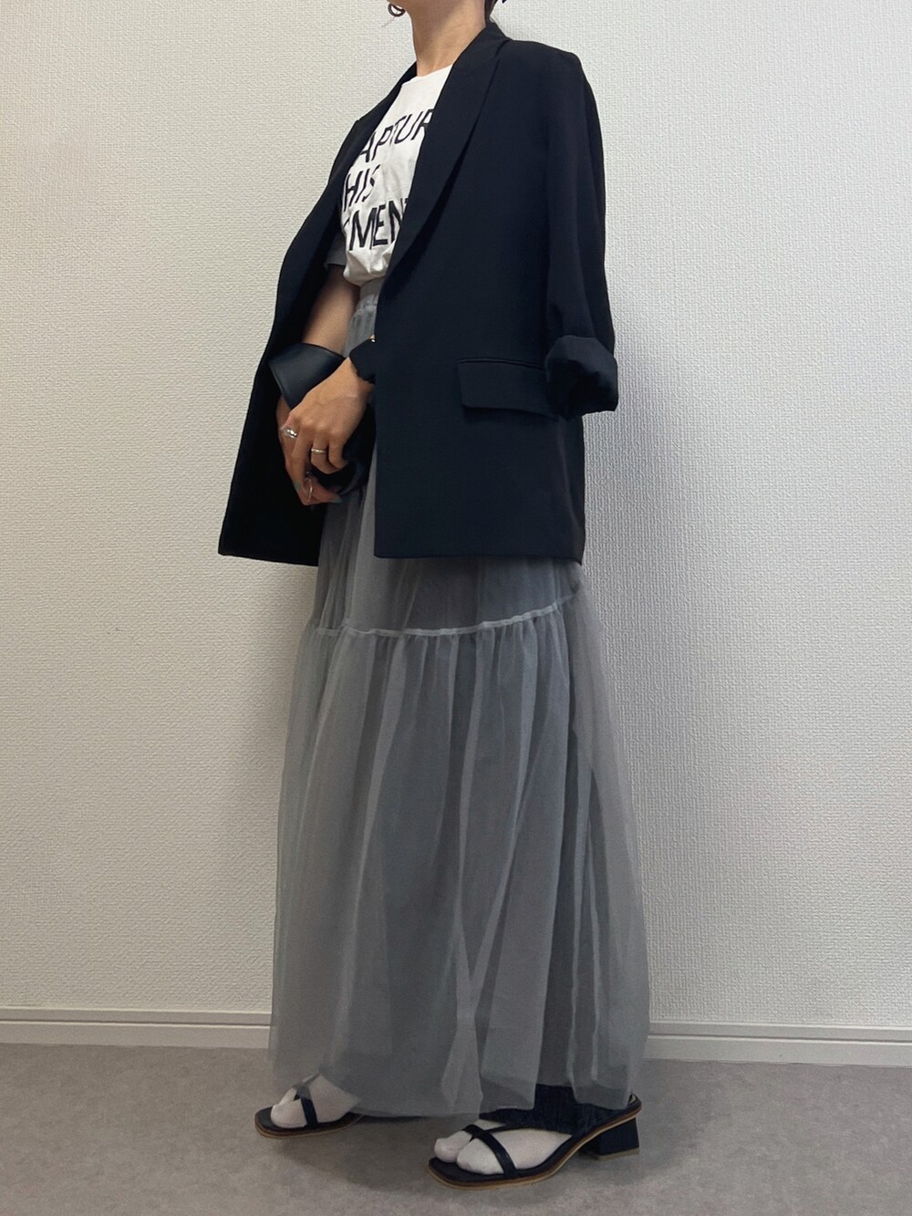 ブラック系のデニムパンツ、ブラック系のサンダルを着用したレディースの春コーディネートの2枚目の写真