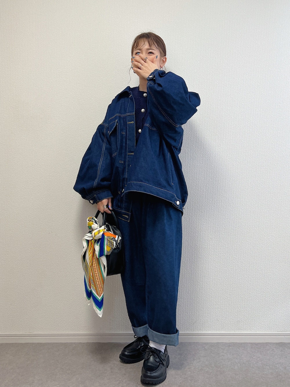 ブルー系のデニムジャケット、ブルー系のデニムパンツ、ブラック系のローファーを着用したレディースの春コーディネートの3枚目の写真