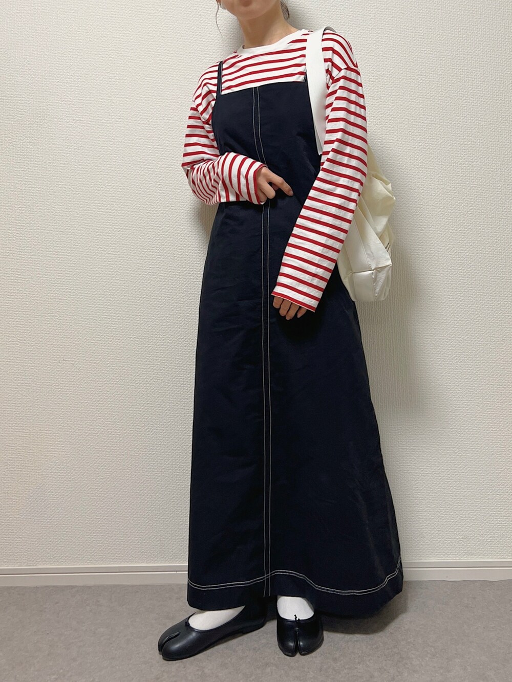 ベージュ系のベスト、ホワイト系のショルダーバッグ、ブラック系のバレエシューズを着用したレディースの春コーディネートの3枚目の写真