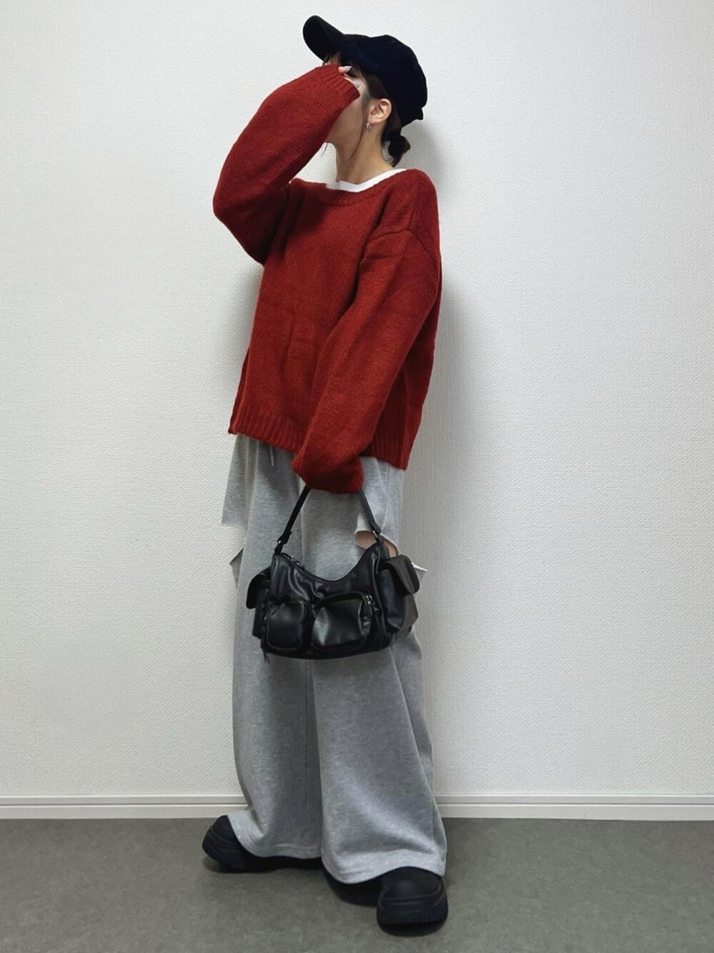 レッド系のカーディガン/ボレロ、ブラック系のブーツ、ブラック系のバッグを着用したレディースの冬コーディネートの2枚目の写真