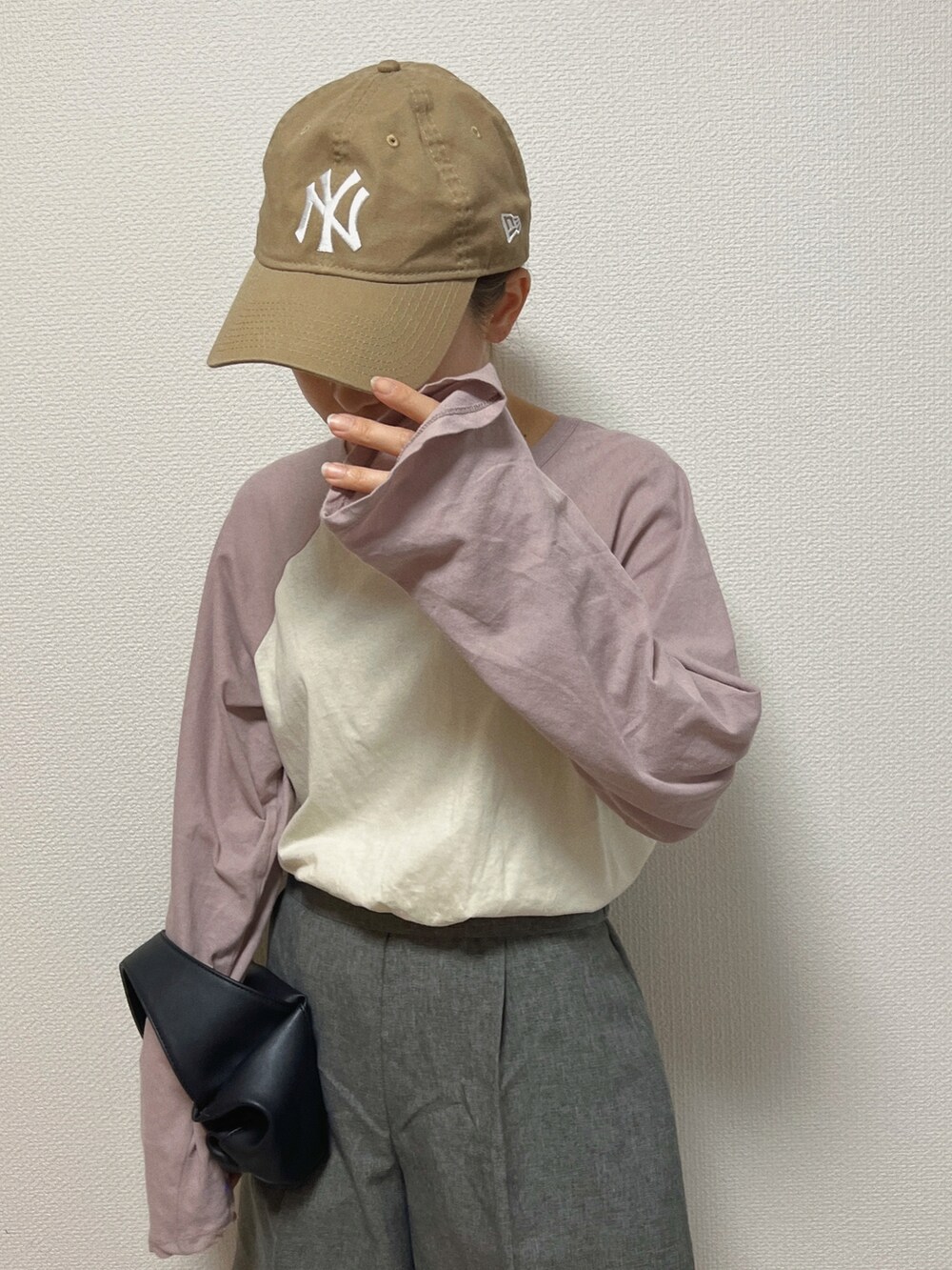 ブラック系のトートバッグ、パープル系のTシャツ/カットソー、ホワイト系のスカートを着用したレディースの春コーディネートの2枚目の写真