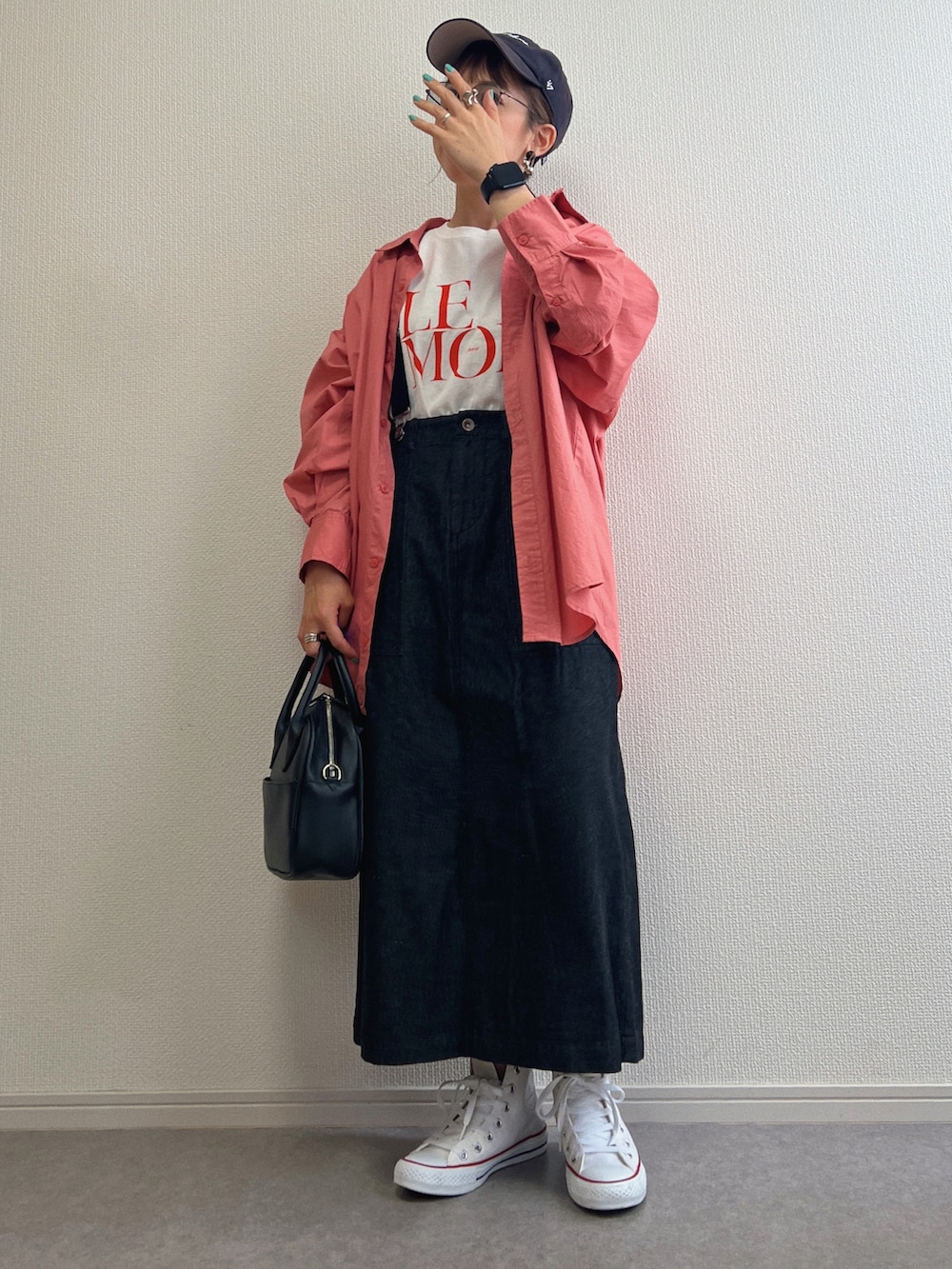 レッド系のTシャツ/カットソー、ピンク系のシャツ/ブラウス、ブラック系のスカートを着用したレディースの春コーディネートの2枚目の写真