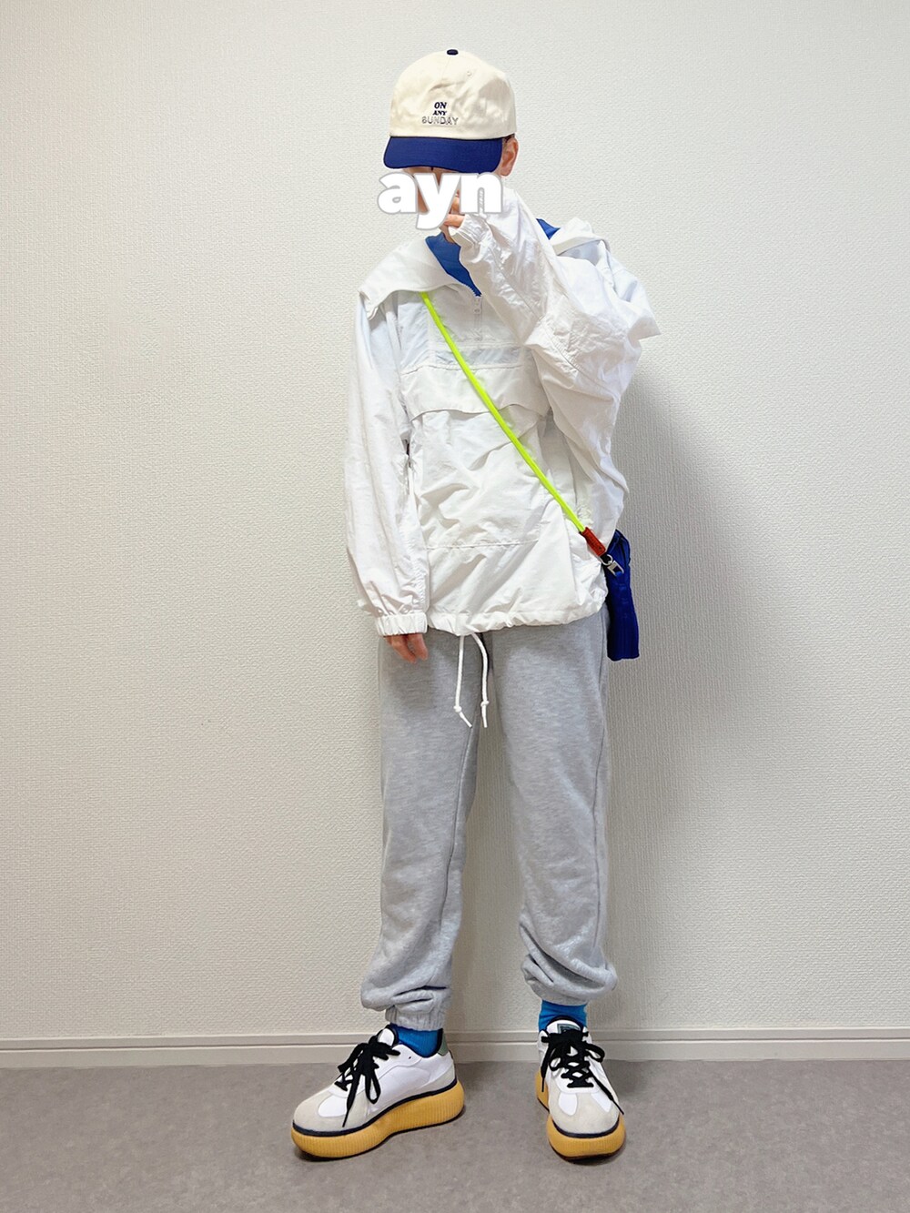 ホワイト系のスニーカー、ブルー系のTシャツ/カットソー、ブルー系のキャップを着用したレディースの春コーディネートの2枚目の写真