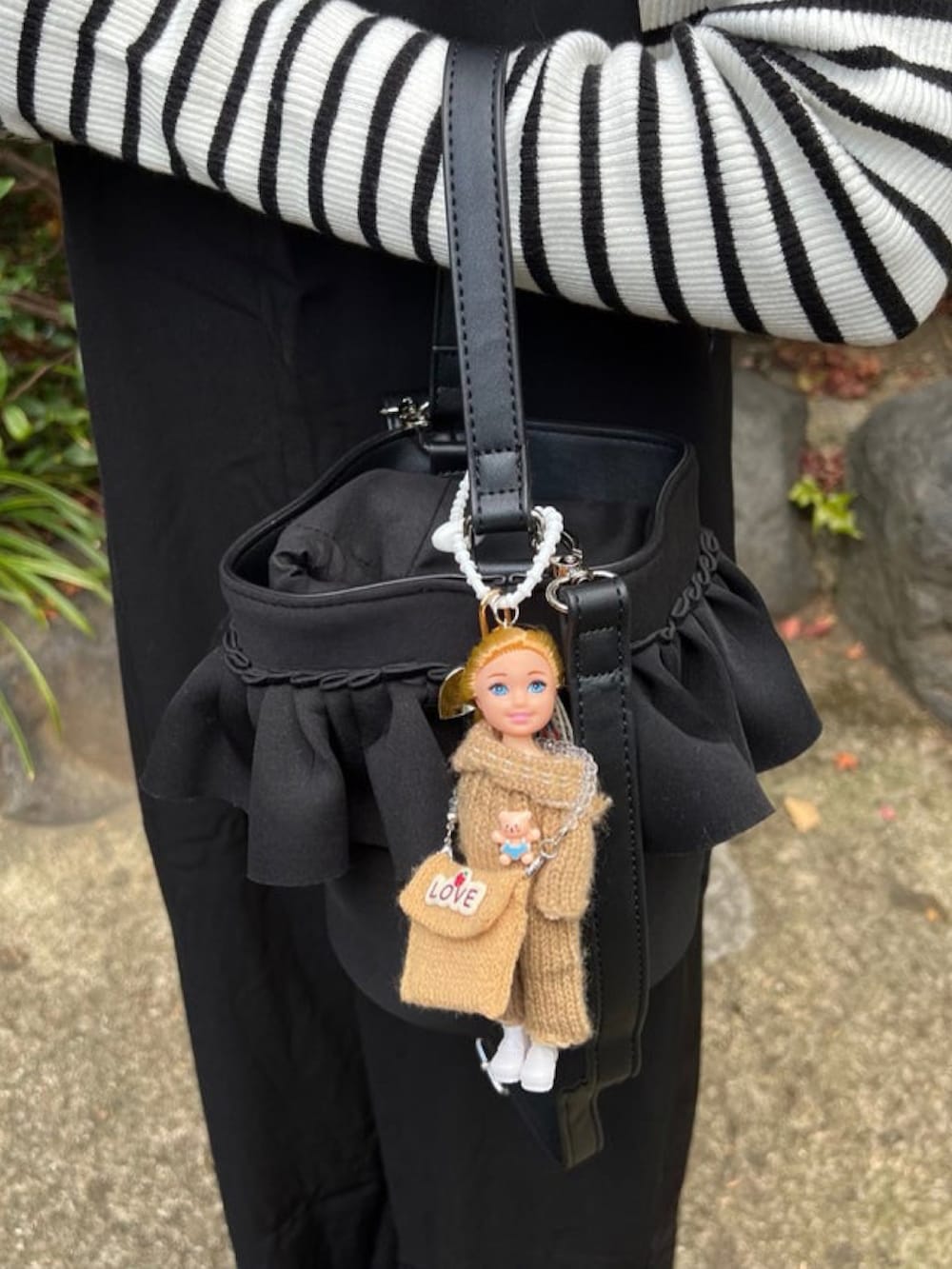 「しまむら、しまむらコーデ、バケツバッグ、リブニット、レイヤードスタイル、サロペット、チャーム、チェスターコート、ロングコート、冬アウター、ブラック、ラクチンコーデ、ブーツスタイル、プチプラ」｜「andmeの無地/ボーダー長袖タートルネック指穴リブニットトップス（ニット/セーター、ホワイト系）」を使った、minmin08_さん（レディース・158cm）の冬コーディネートの2枚目の写真