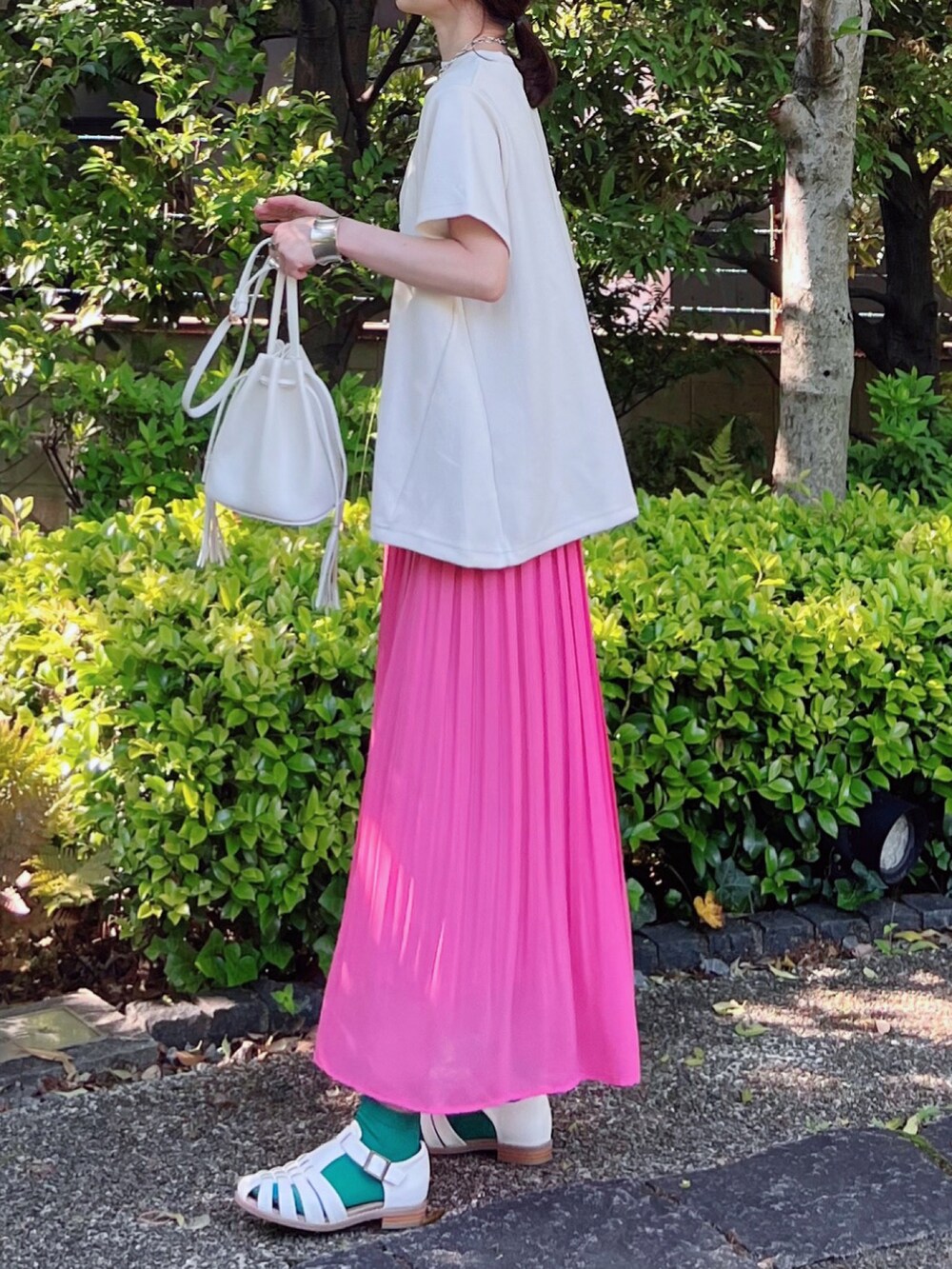 ホワイト系のTシャツ/カットソー、ピンク系のスカート、ホワイト系のショルダーバッグを着用したレディースの春コーディネートの2枚目の写真