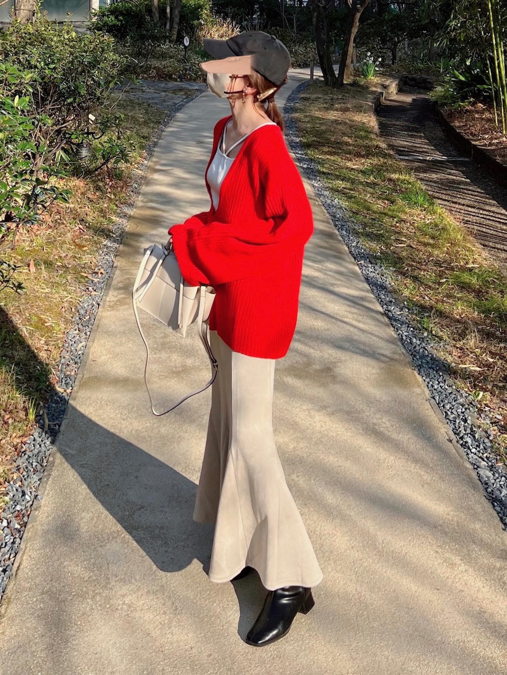 ホワイト系のTシャツ/カットソー、レッド系のニット/セーター、ホワイト系のスカートを着用したレディースの冬コーディネートの2枚目の写真