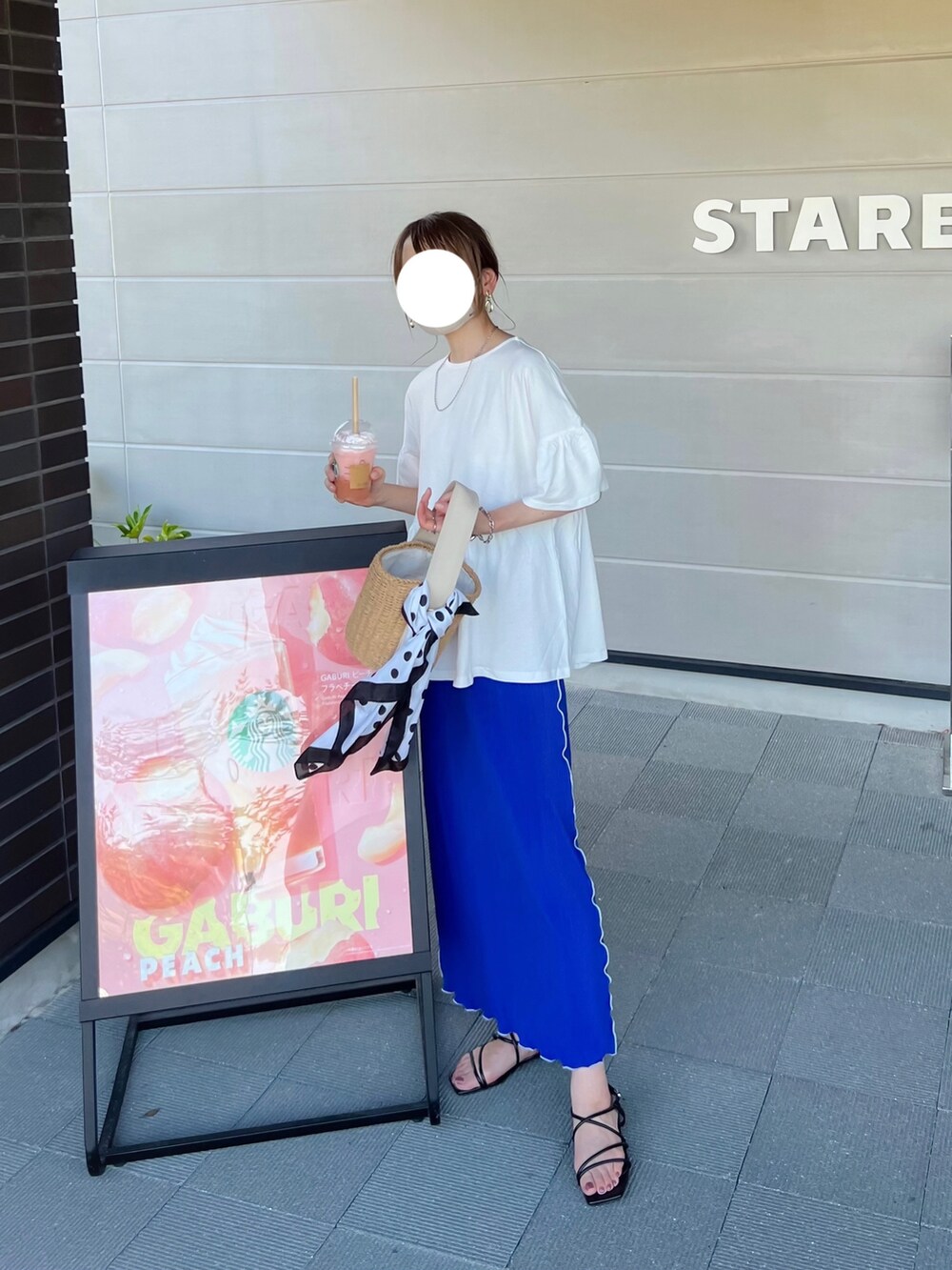 ホワイト系のTシャツ/カットソー、ブルー系のスカート、ベージュ系のかごバッグを着用したレディースの夏コーディネートの2枚目の写真