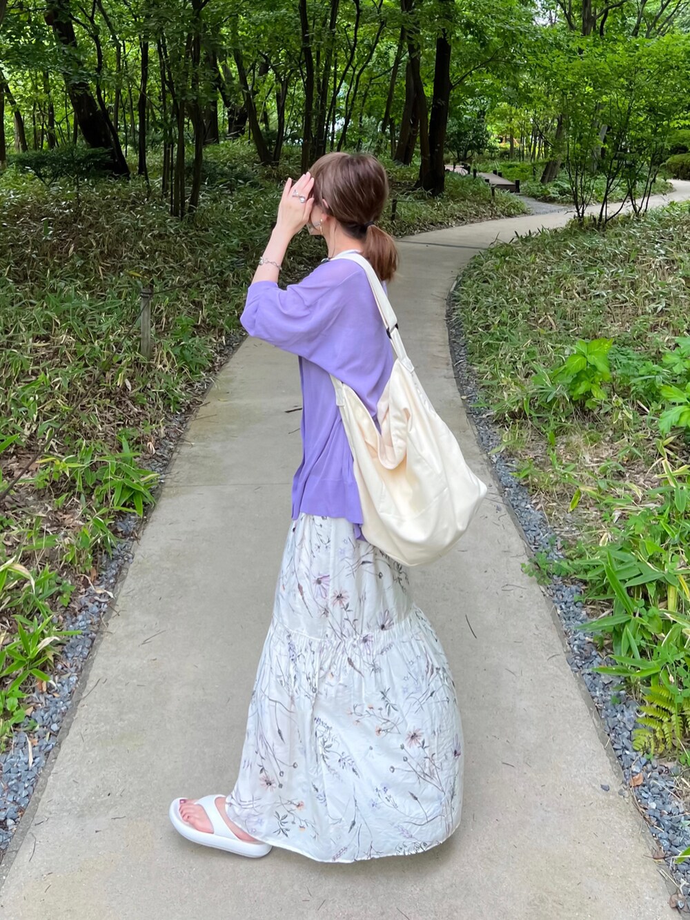 ホワイト系のスカート、パープル系のカーディガン/ボレロ、ブラック系のキャミソールを着用したレディースの夏コーディネートの2枚目の写真