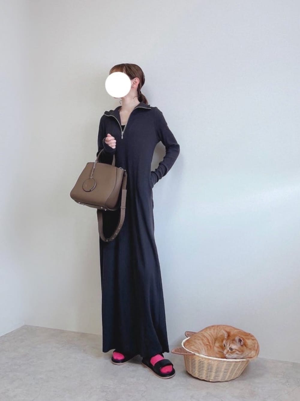 ホワイト系のナイロンジャケット、ブラック系のワンピース、ブラウン系のトートバッグを着用したレディースの冬コーディネートの3枚目の写真