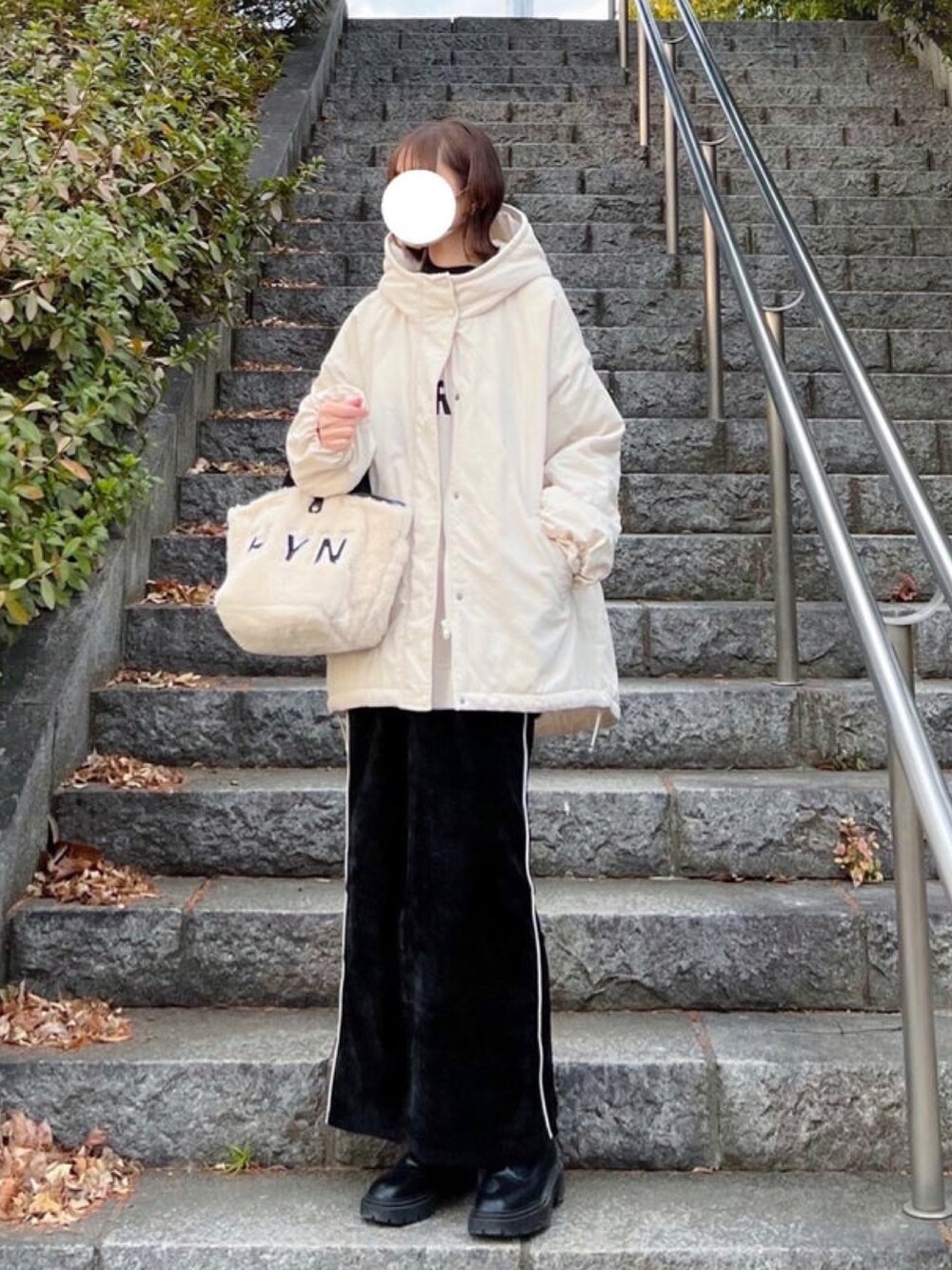 ホワイト系のスウェット、ブラック系のスカート、ホワイト系のトートバッグを着用したレディースの冬コーディネートの4枚目の写真