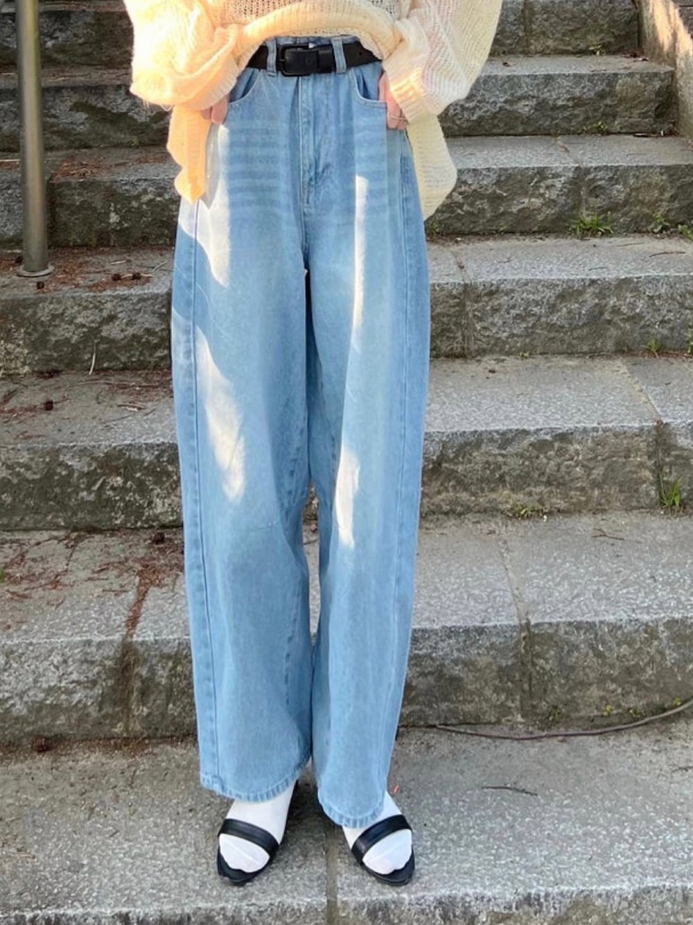 ホワイト系のニット/セーター、ブラック系のタンクトップ、ブルー系のデニムパンツを着用したレディースの冬コーディネートの3枚目の写真