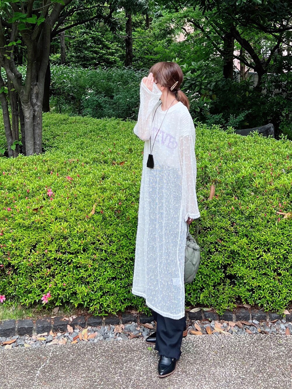 ホワイト系のワンピース、ホワイト系のTシャツ/カットソー、ブラック系のパンツを着用したレディースの春コーディネートの2枚目の写真