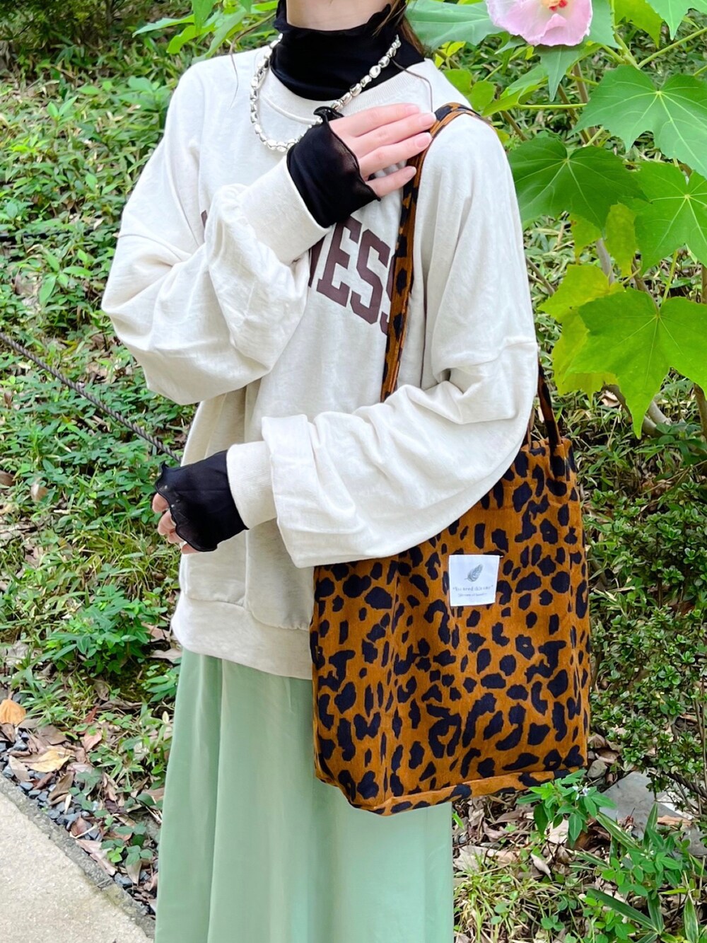 ブラウン系のスウェット、グリーン系のスカート、その他のトートバッグを着用したレディースの秋コーディネートの2枚目の写真