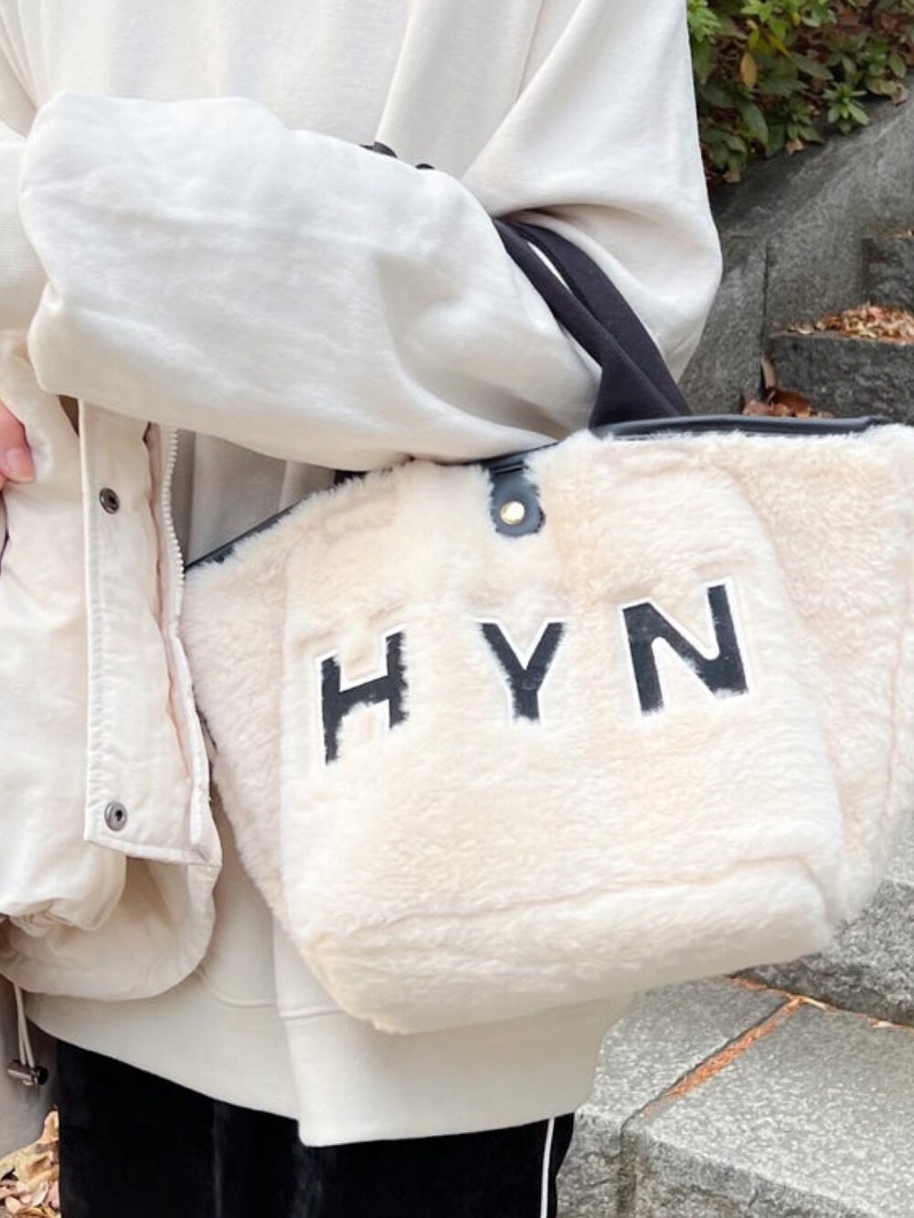 ホワイト系のスウェット、ブラック系のスカート、ホワイト系のトートバッグを着用したレディースの冬コーディネートの2枚目の写真