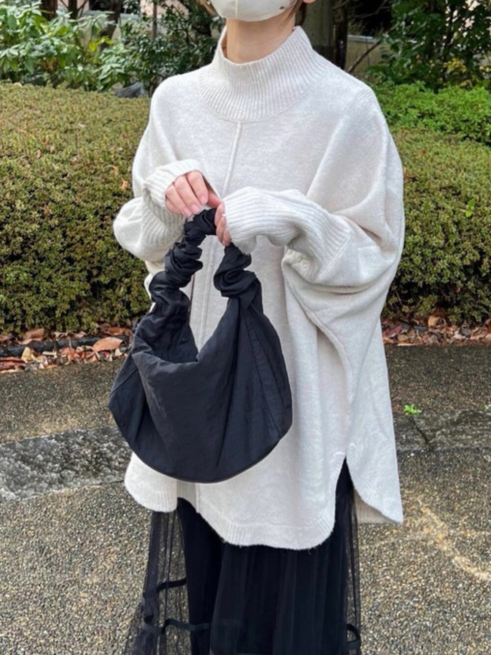 ベージュ系のニット/セーター、ブラック系のショルダーバッグ、ブラック系のスカートを着用したレディースの冬コーディネートの2枚目の写真