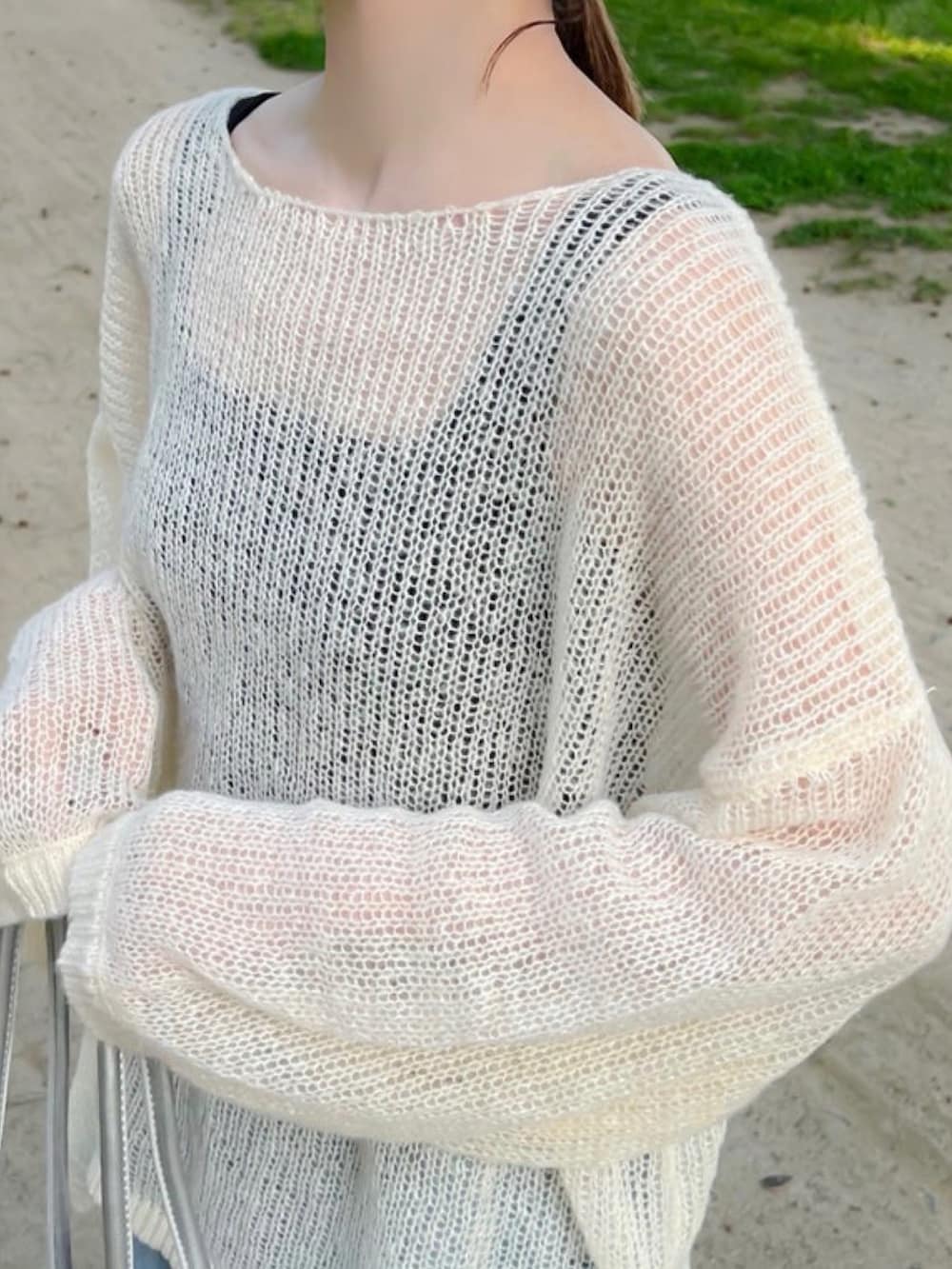 ホワイト系のニット/セーター、ブラック系のタンクトップ、ブルー系のデニムパンツを着用したレディースの冬コーディネートの4枚目の写真